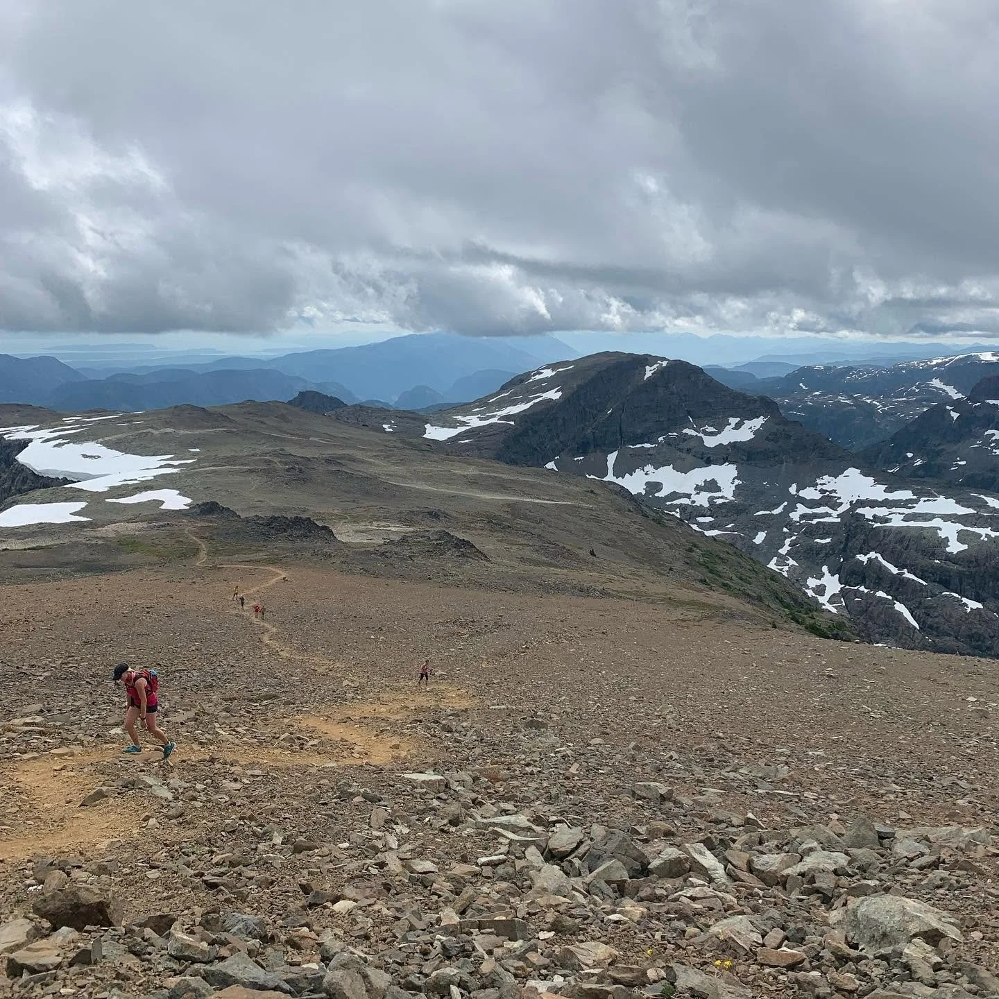 Runner climbing toward an alpine mountain summit