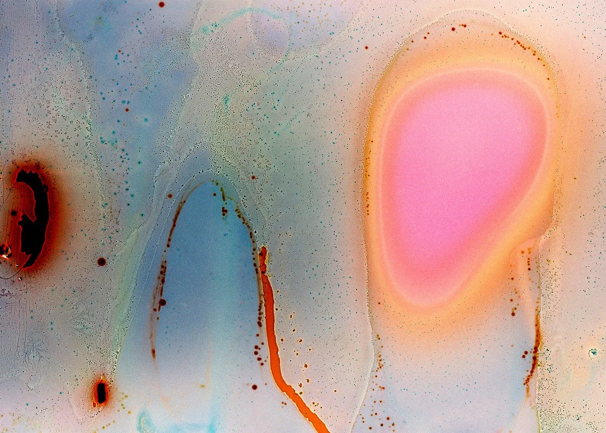 Abstract colorful artwork with splashes of pink, blue, red, and orange hues, resembling a fluid or watercolor painting.