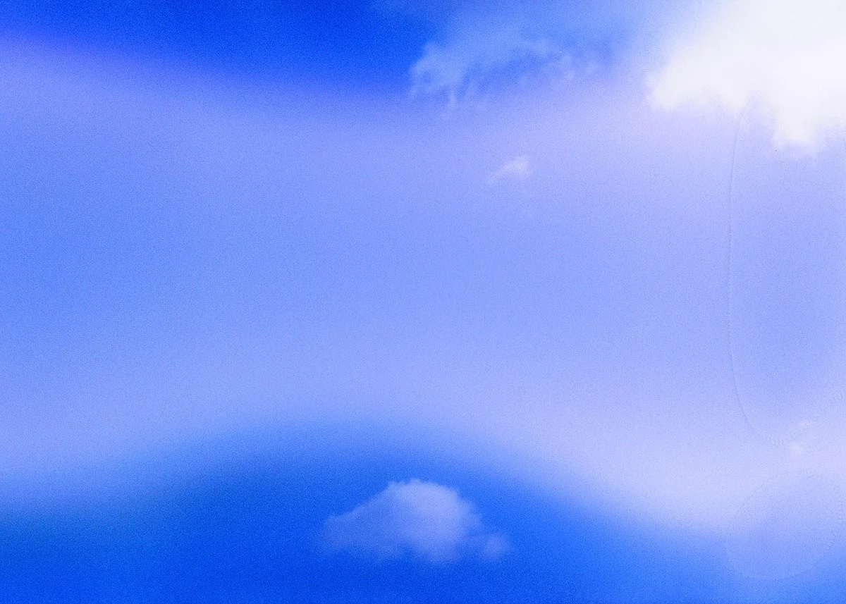 Blue sky with some scattered clouds and a large bright cloud in the top right corner.
