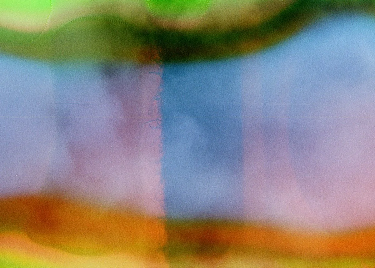 Abstract colorful blurred background with vibrant shades of green, purple, blue, orange, and pink.