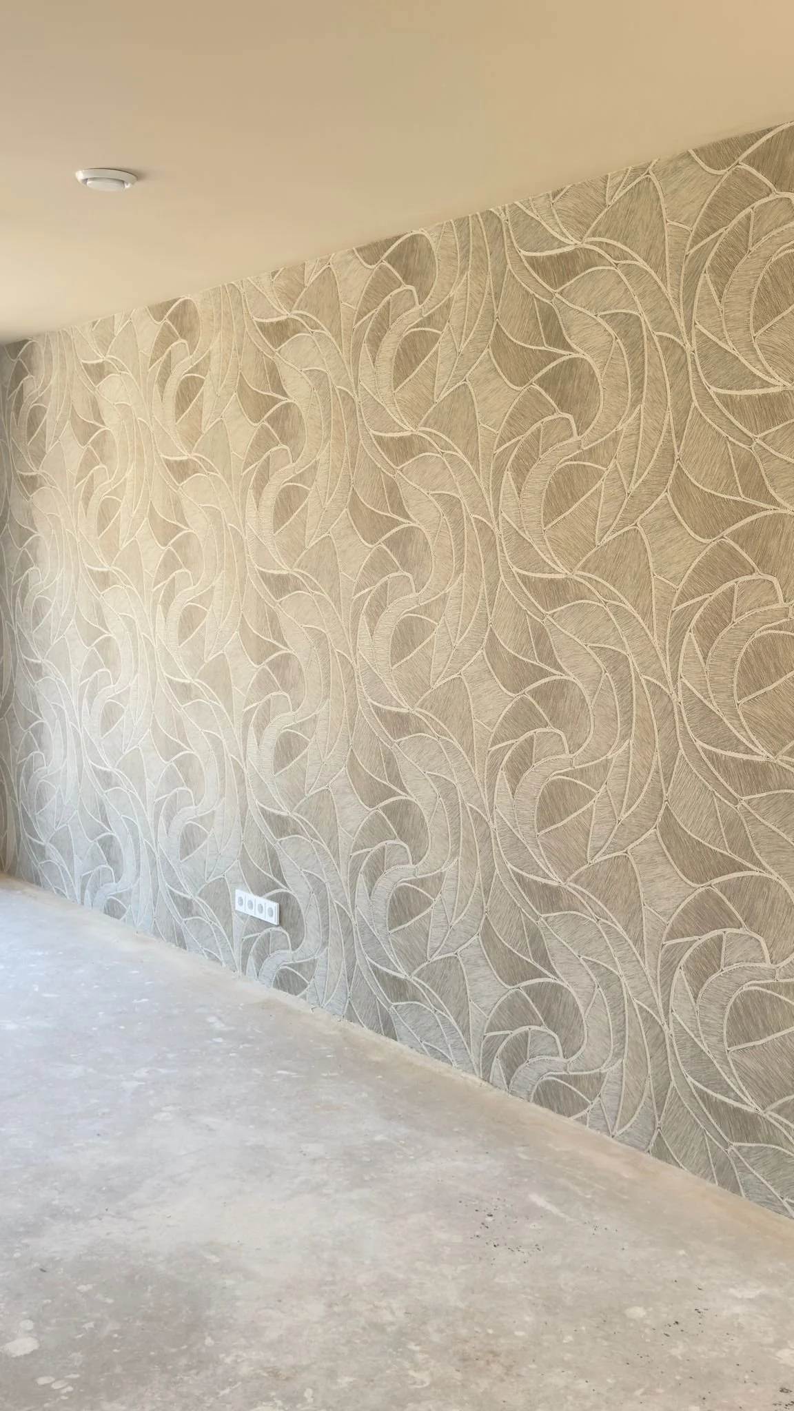 Beige behang met bladmotief professioneel aangebracht in interieur