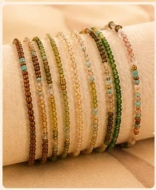 Multiple beaded bracelets in various colors displayed on a cylindrical holder.