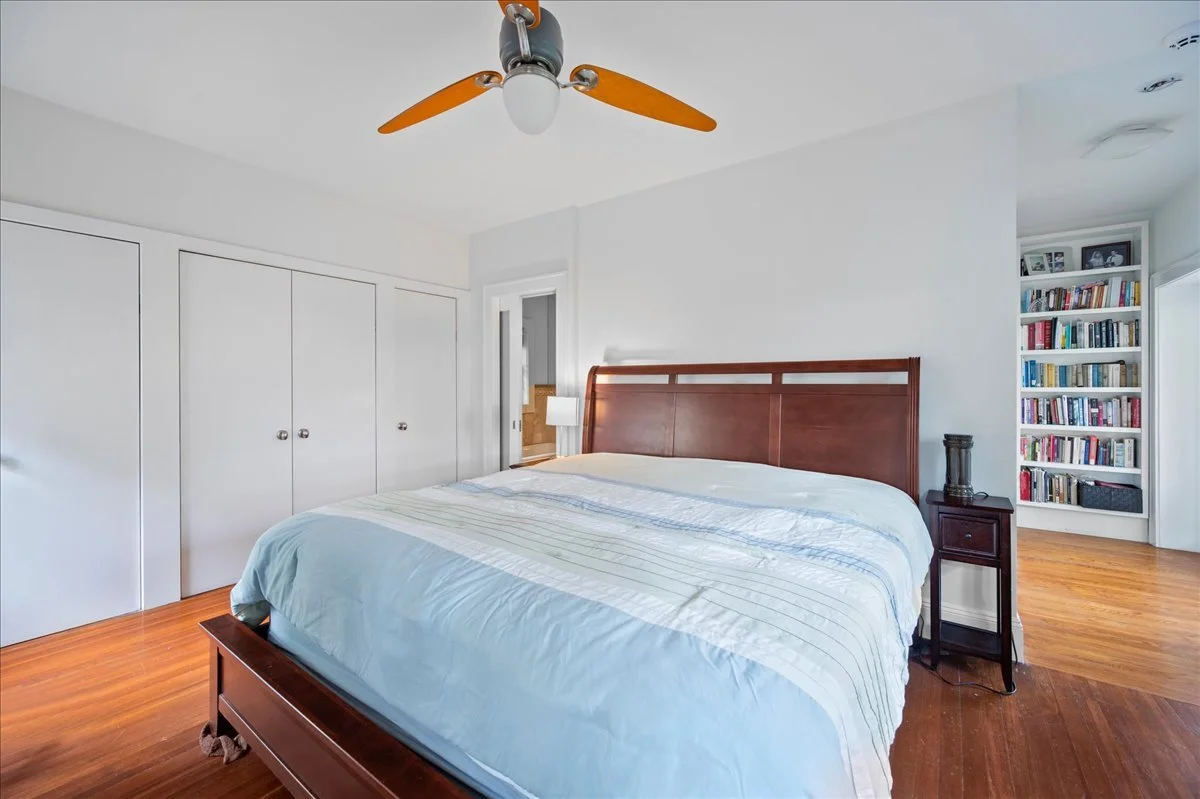 Second Level Master Bedroom, three closets, extensive built-in bookcases, Eastern and Southern exposures, adjacent enclosed sunroom, electric fireplace