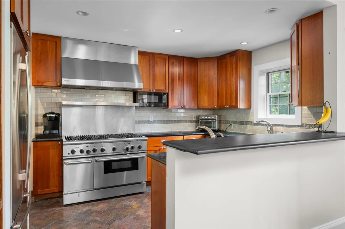Professional-grade stainless range, hood, commercial oven, built-in microwave tile backsplash, wood cabinetry, Silestone countertops, stone tile flooring, Eastern and Western exposures, Bosch dishwasher
