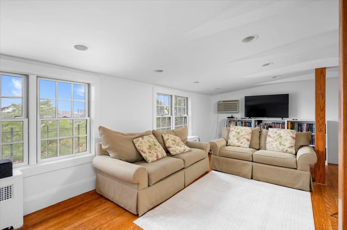 Skylit third-floor Fourth Bedroom (or family room/home office) with Eastern street view and Western garden view; built-in bookcases, full bath, two storage areas