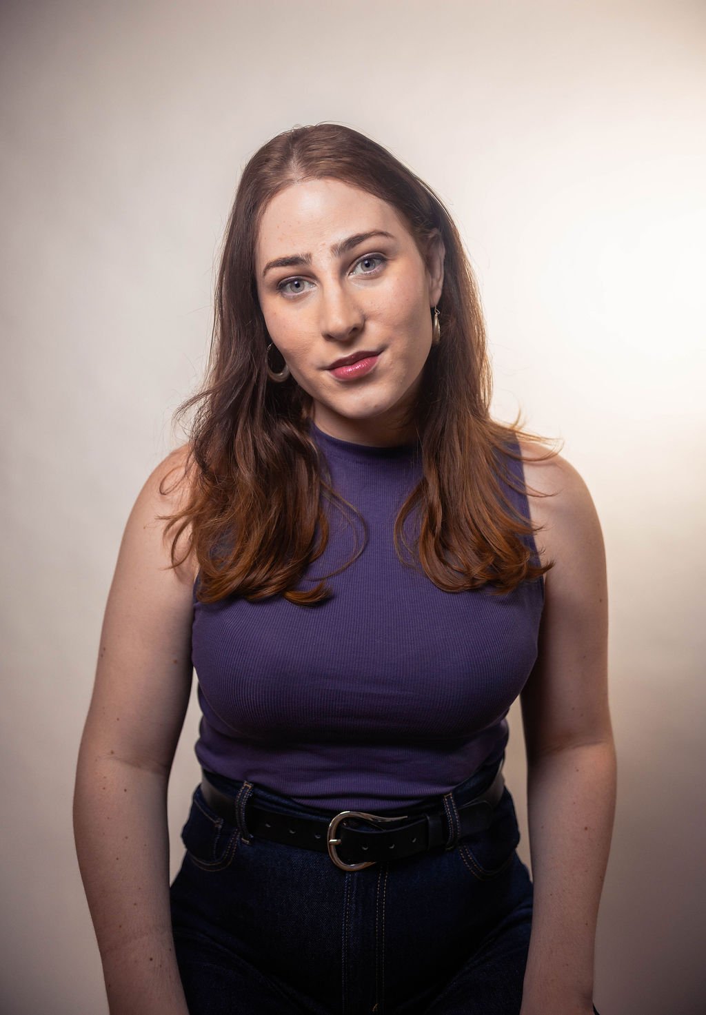 Portrait of Ky Albert wearing a sleeveless purple top against a neutral background.