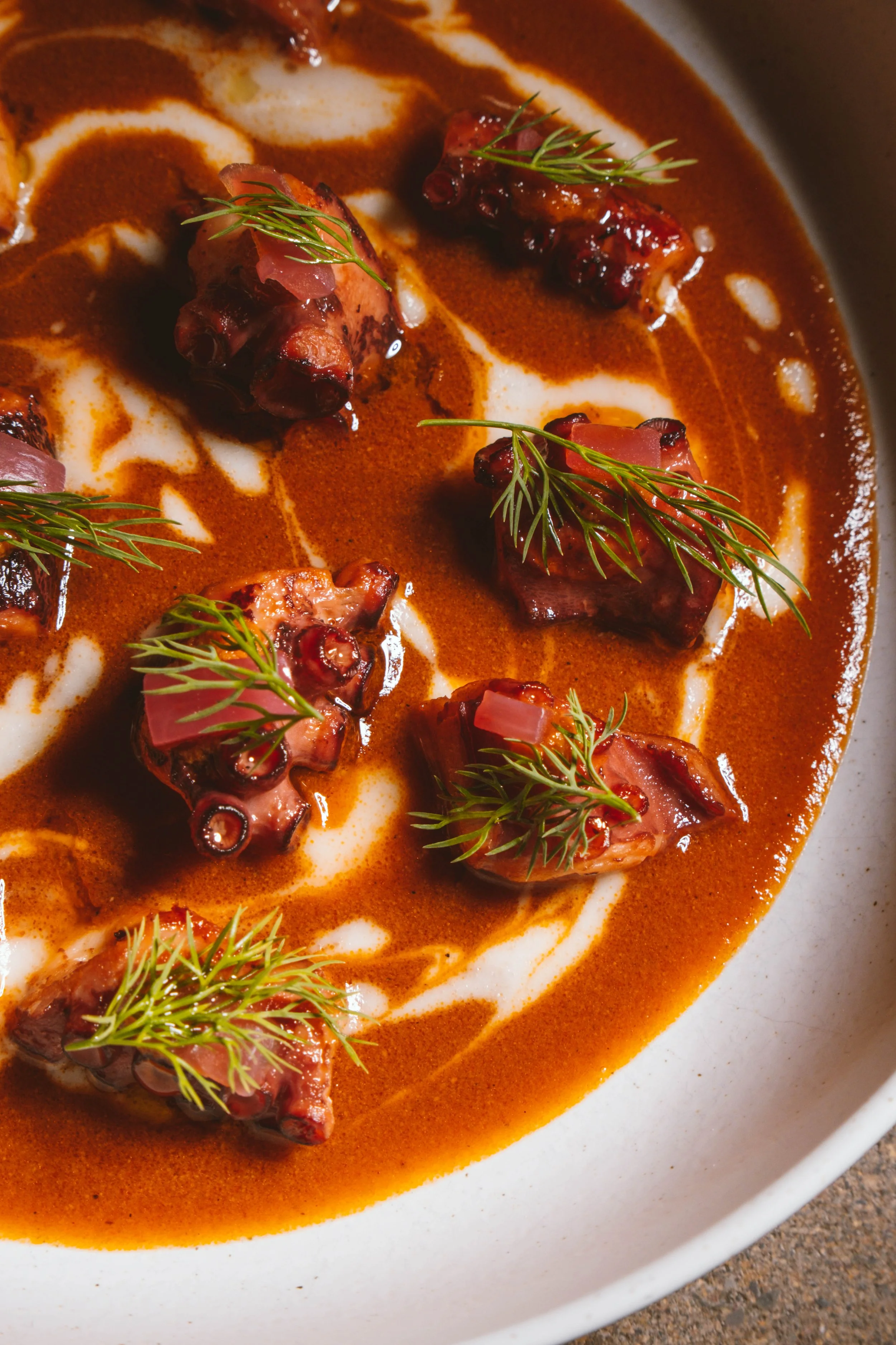 Plato de carne en salsa con hierbas frescas y crema, decorado con eneldo.