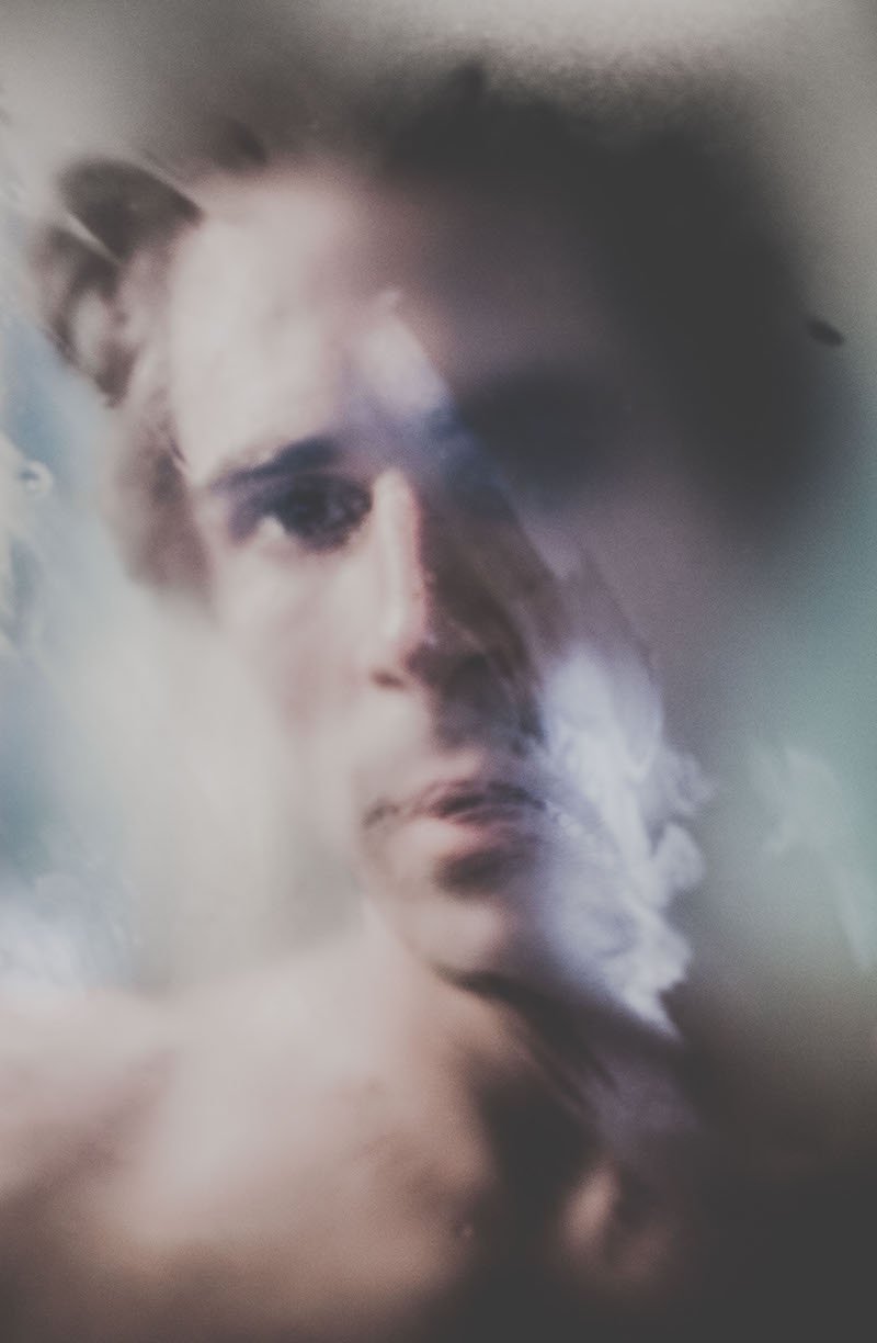 Retrato artístico de una mujer joven con expresión pensativa, con efectos de distorsión y difuminado en la imagen.