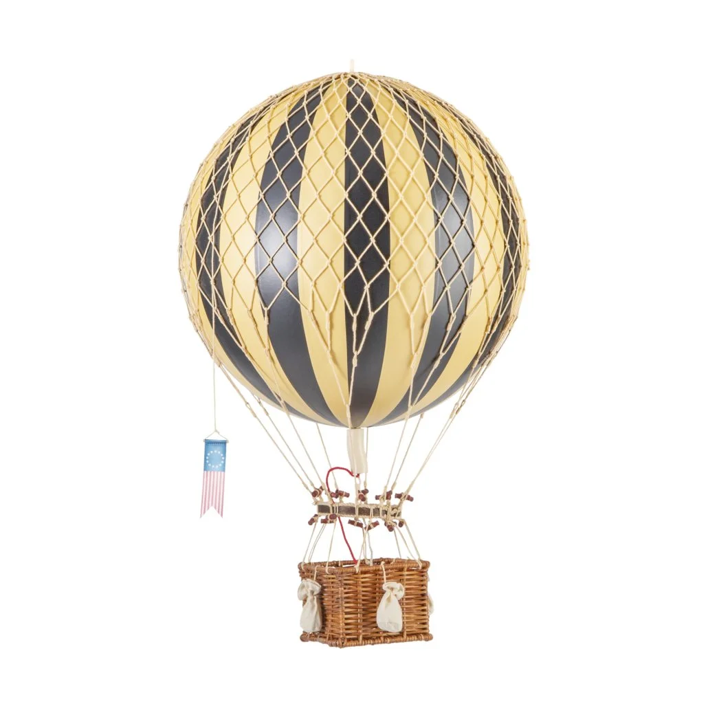 Montgolfière avec un ballon noir et beige avec des motifs rayés, une nacelle en osier, et un petit drapeau avec un motif étoilé