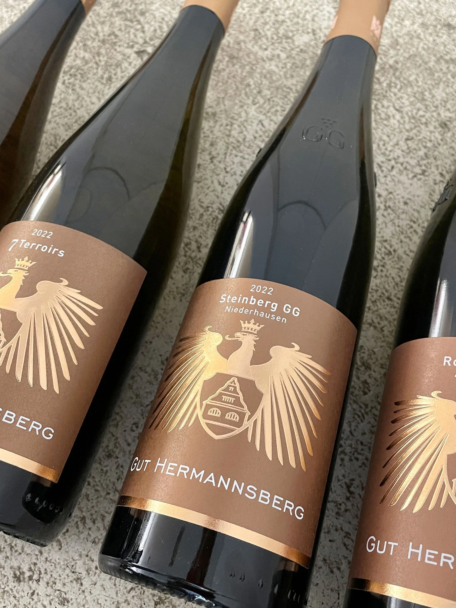 Drei Weinflaschen mit Wappen des Gut Hermannsberg 