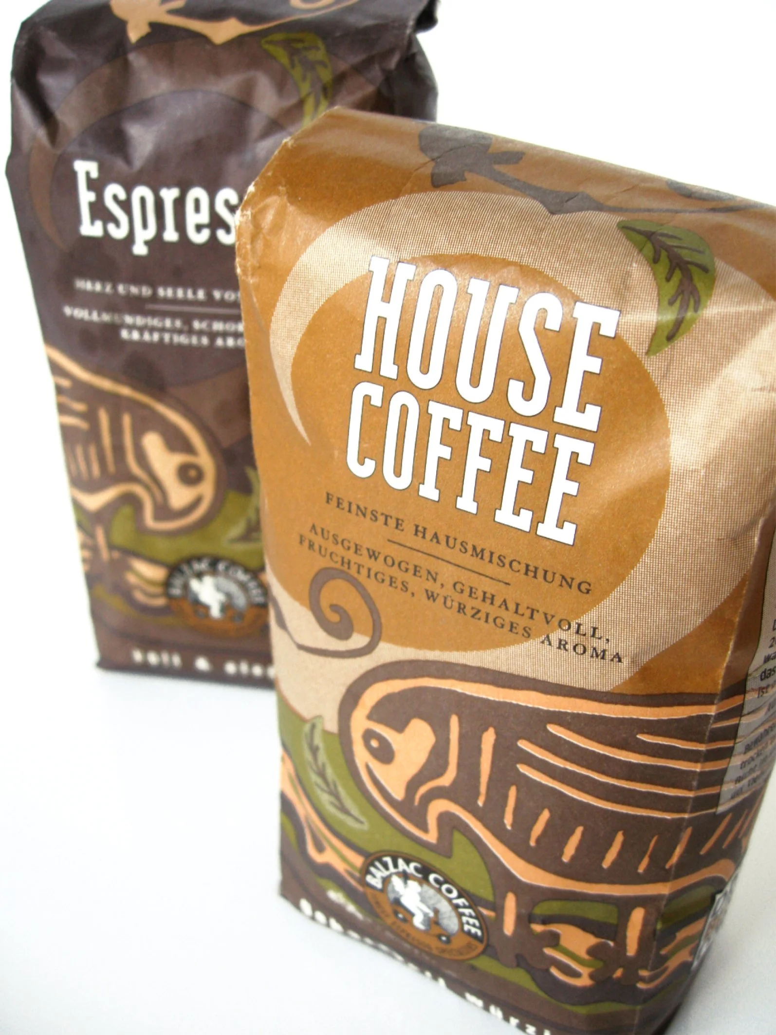 Pakete von Kaffee, eines in brauner Verpackung mit dem Schriftzug 'House Coffee' und das andere in dunkler Verpackung mit dem Schriftzug 'Espresso'.