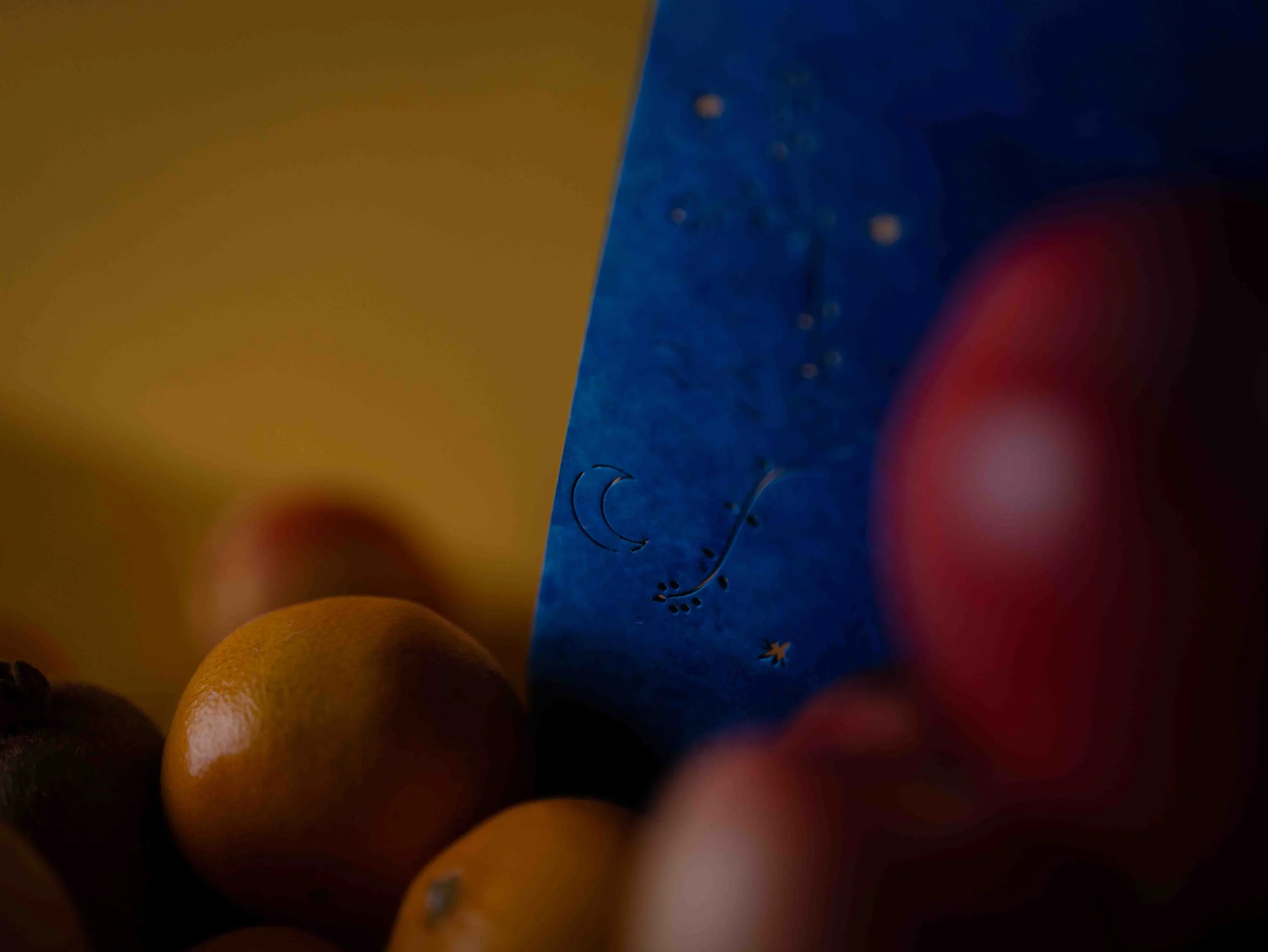 Close-up of colorful round objects, possibly fruits or candies, with dark and vibrant lighting.