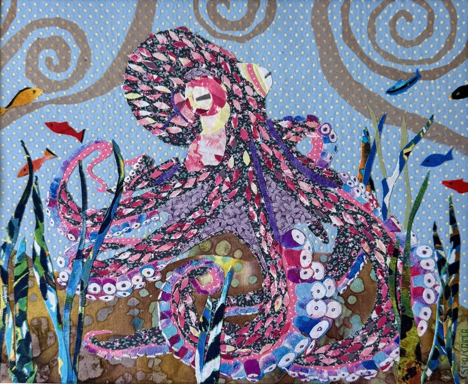 Colorful fabric collage depicting a fairy with butterfly wings, surrounded by underwater plants and fish, against a blue polka dot background.
