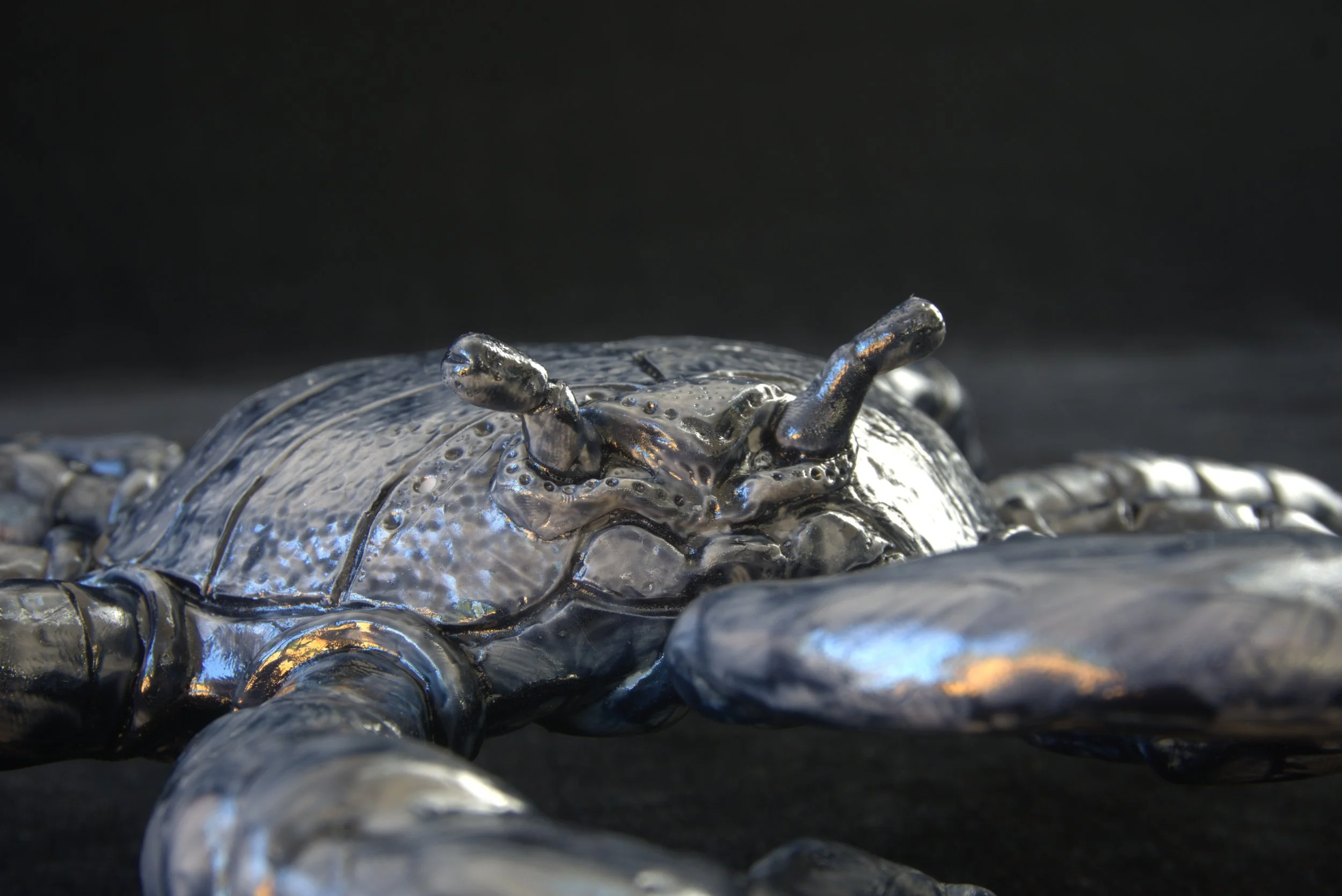 Close-up image of metallic metallic-appearing objects with a glossy surface, piled together against a dark background.