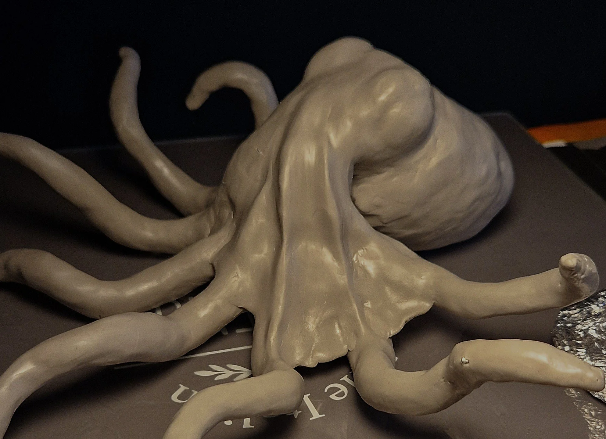 A large skull sculpture with elongated tentacle-like extensions surrounding it.