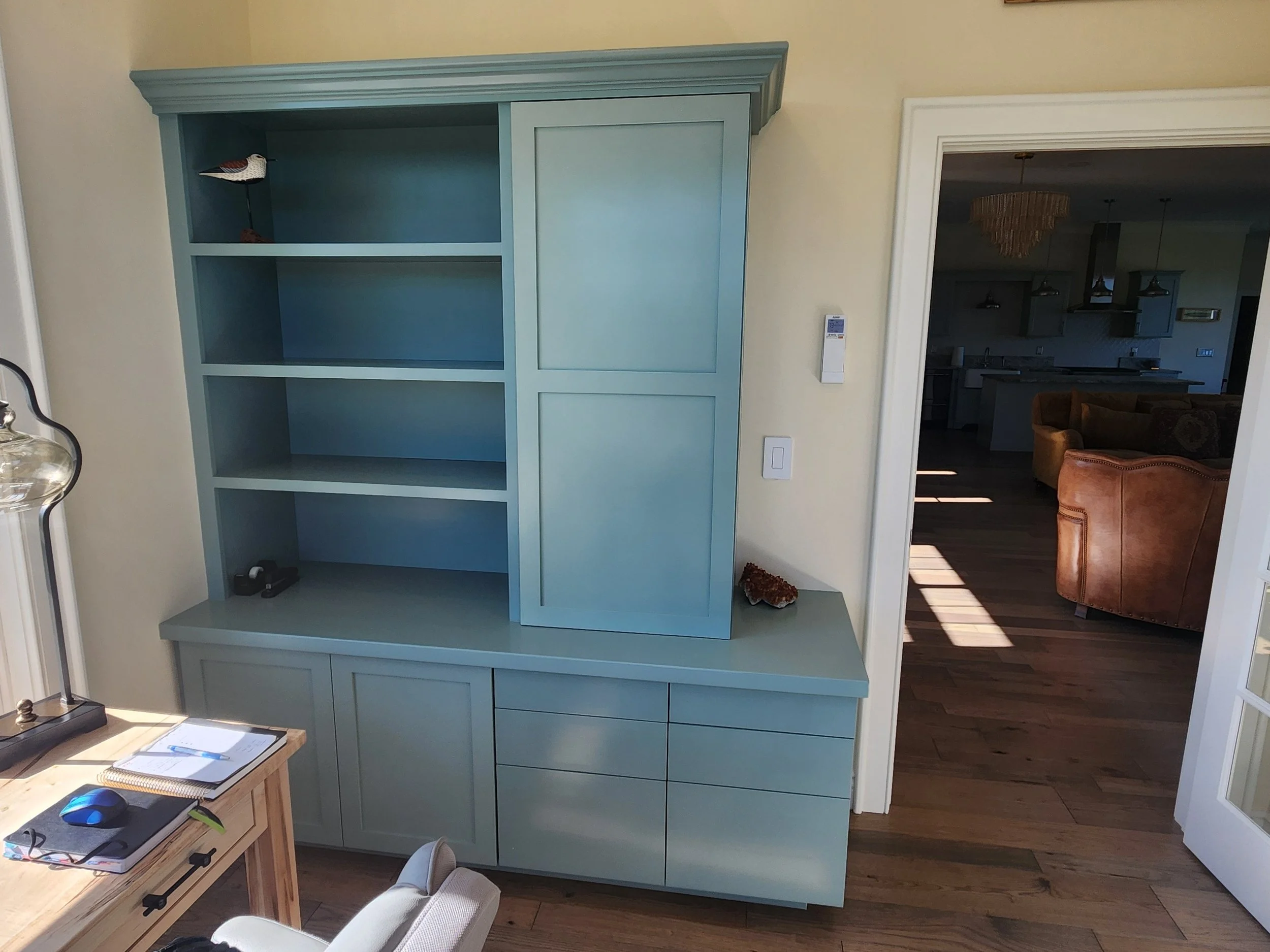 A sturdy, freshly painted blue shelving unit, located in a room with a doorway to the right.