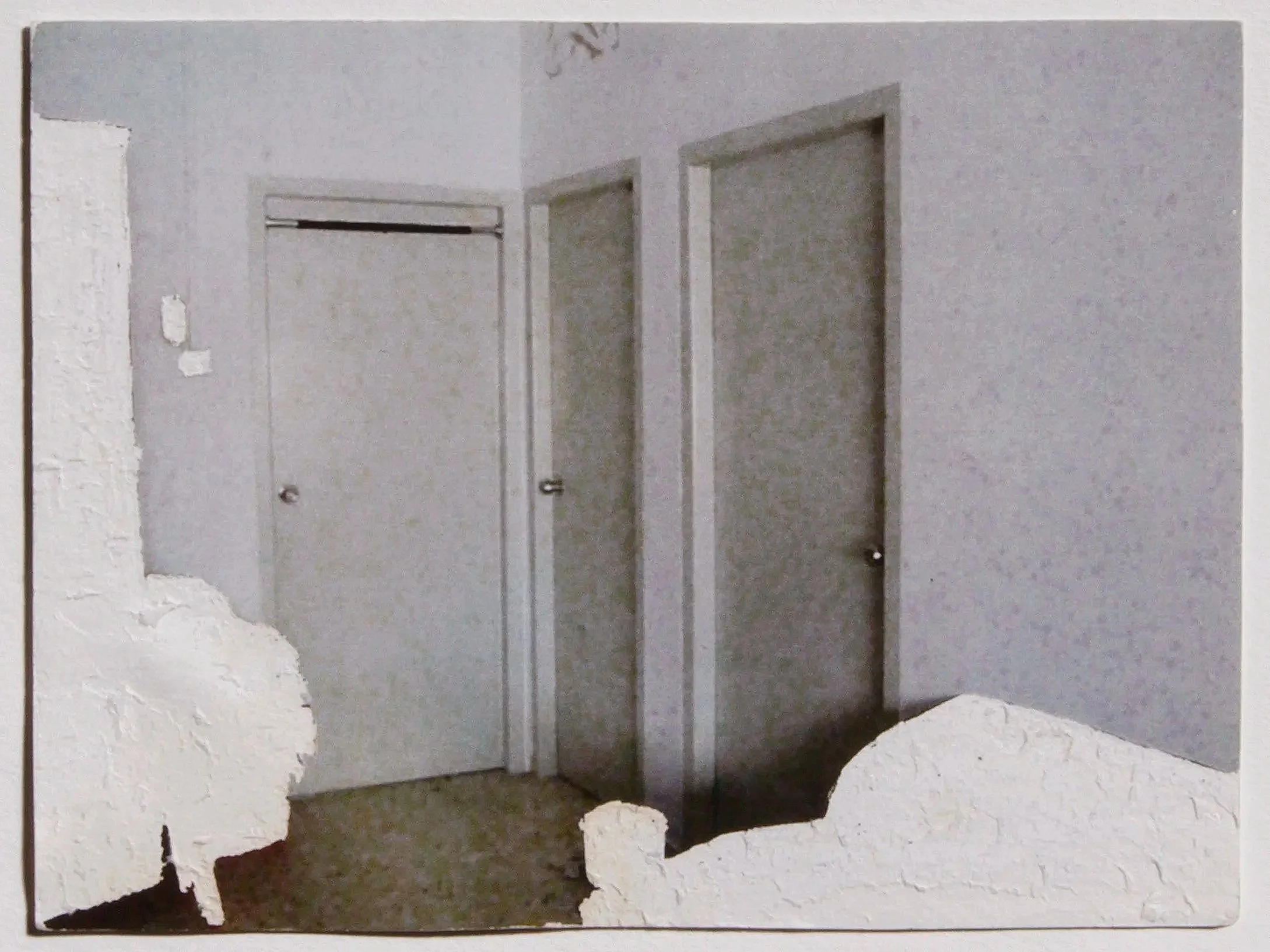 Haunting image of the interior of a home with three grey doors, and swathes of white masses where the furniture used to be.