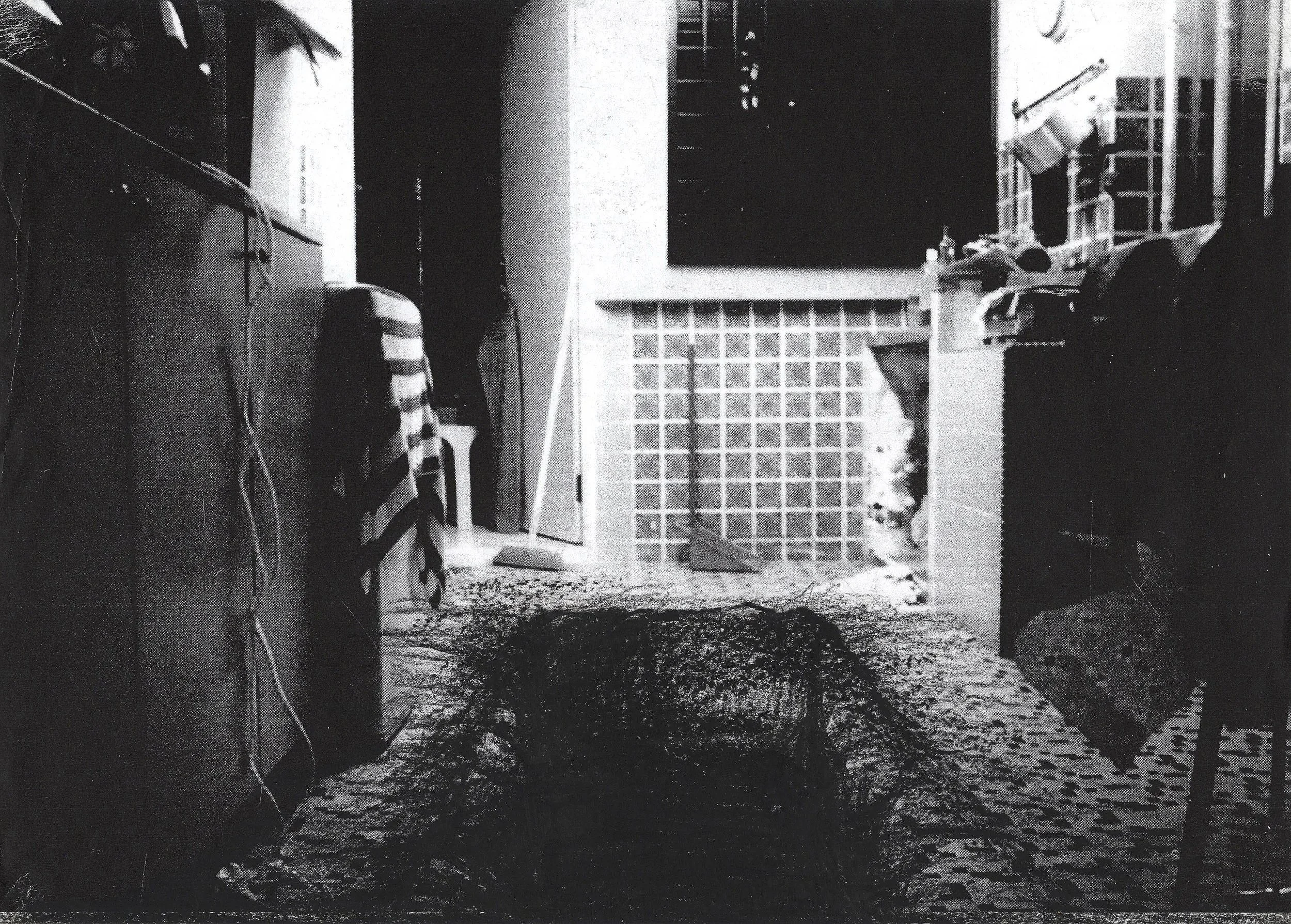 Somber and melancholic black and white collage of a home in Singapore with a large black grave dug into its floor.