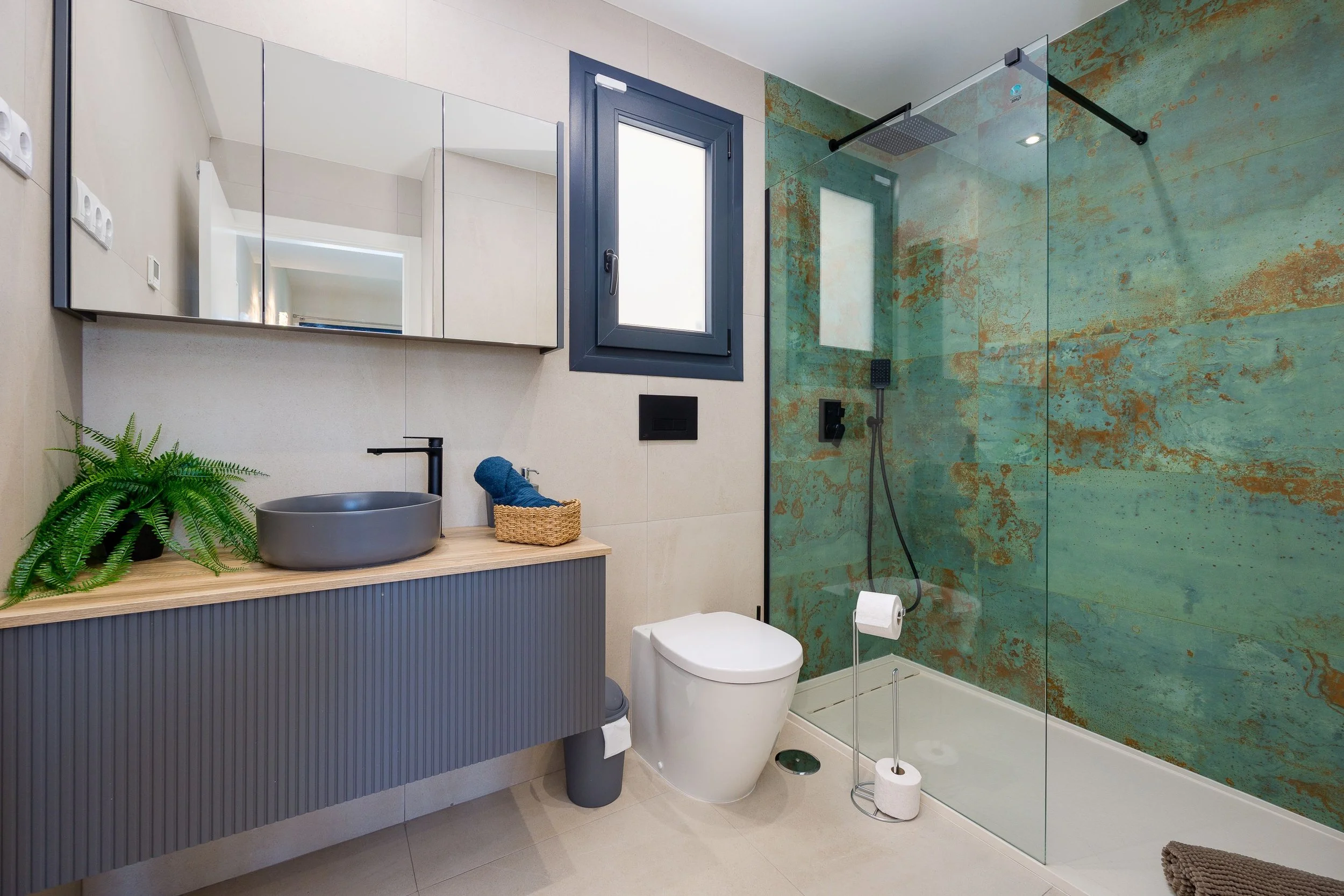The stylish en-suite bathroom features a luxurious rainfall shower and floor heating.
