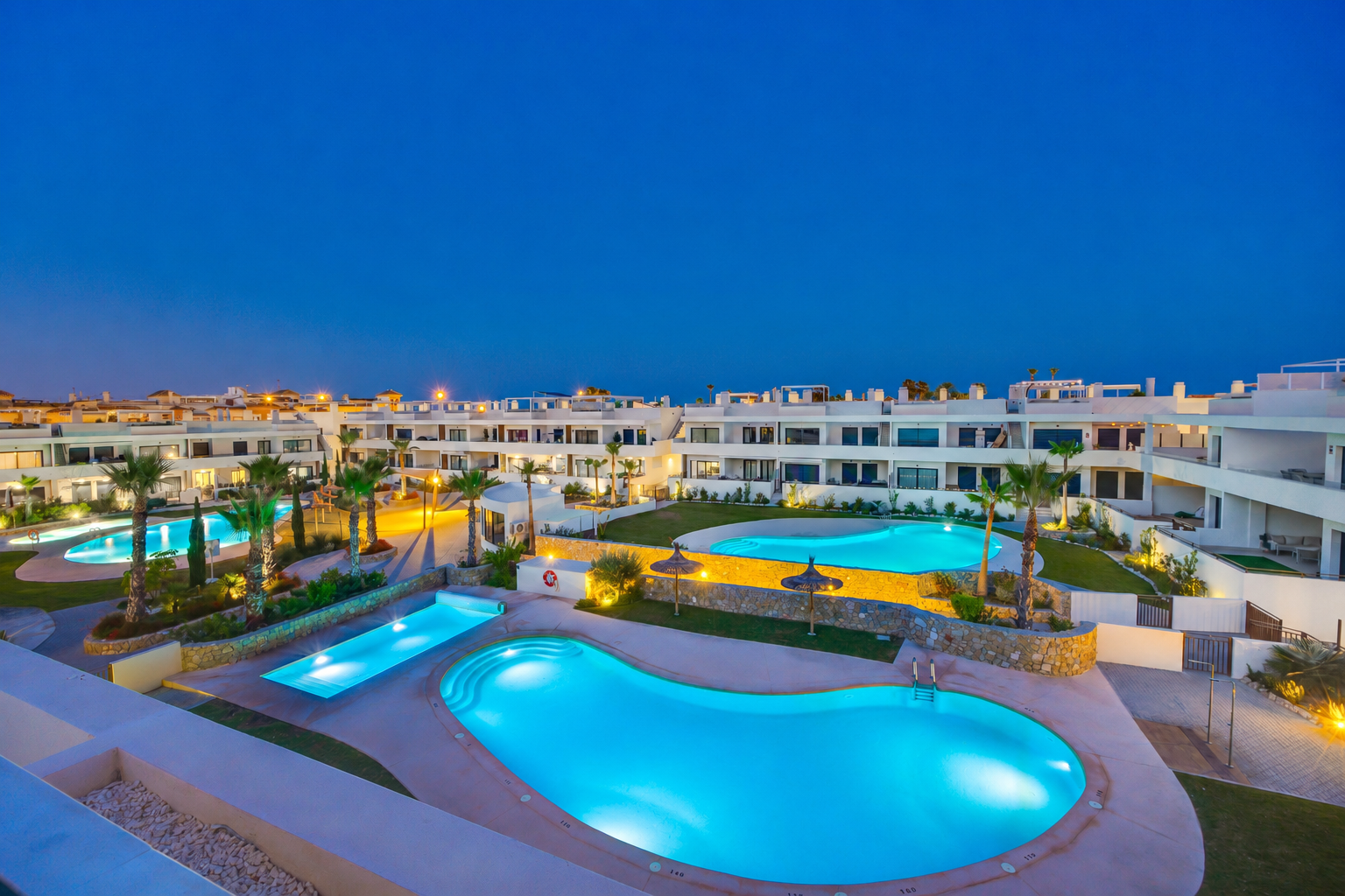 Beautifully lit pools create a peaceful evening setting.