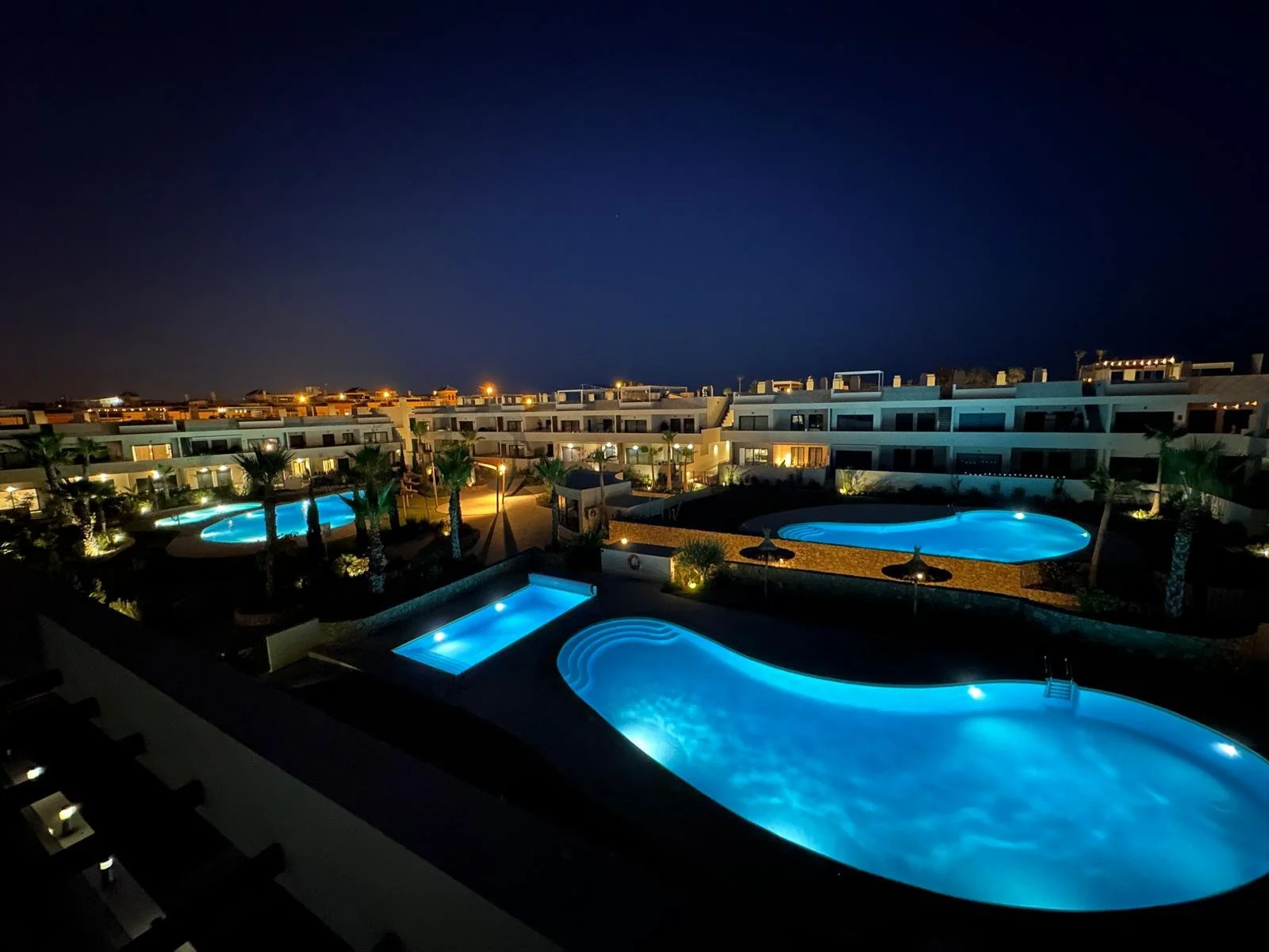 Enjoy a peaceful evening beside the beautifully lit swimming pools.