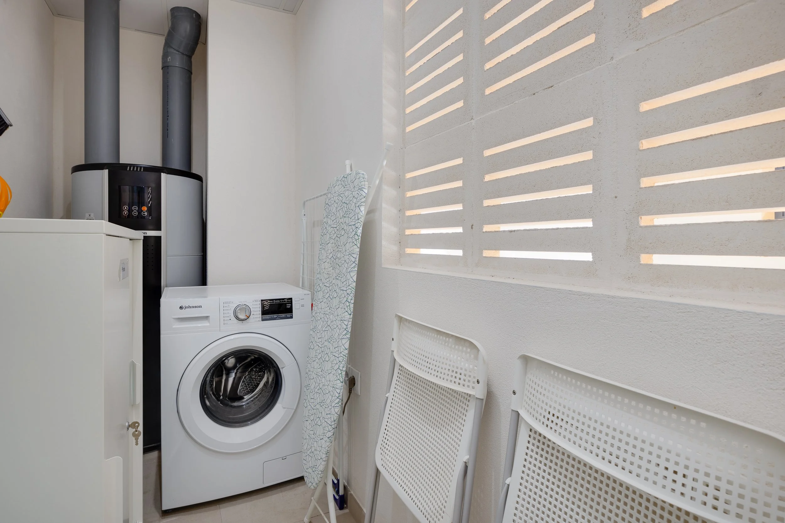 Convenient utility room with washing machine and storage.