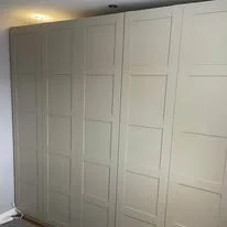 Large white closet with multiple panel doors in a room