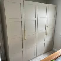 White built-in closet with four doors and gold handles