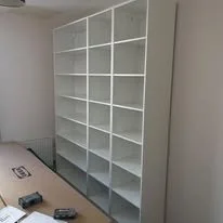 Empty white bookshelf with multiple shelves in a room
