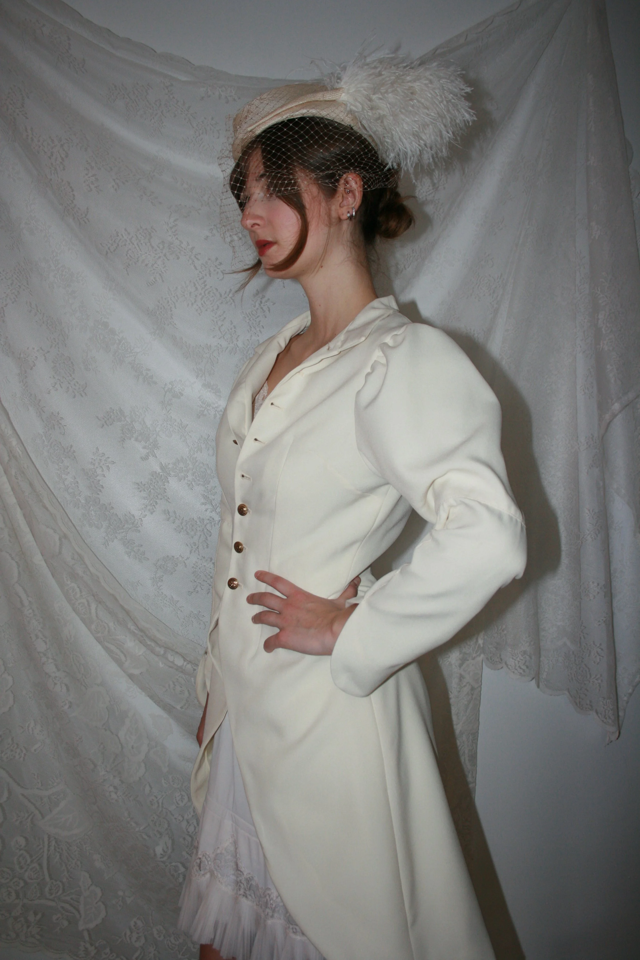 wool gaberdine coat with gathered 3 piece sleeves, standing collar, and gold shank buttons 