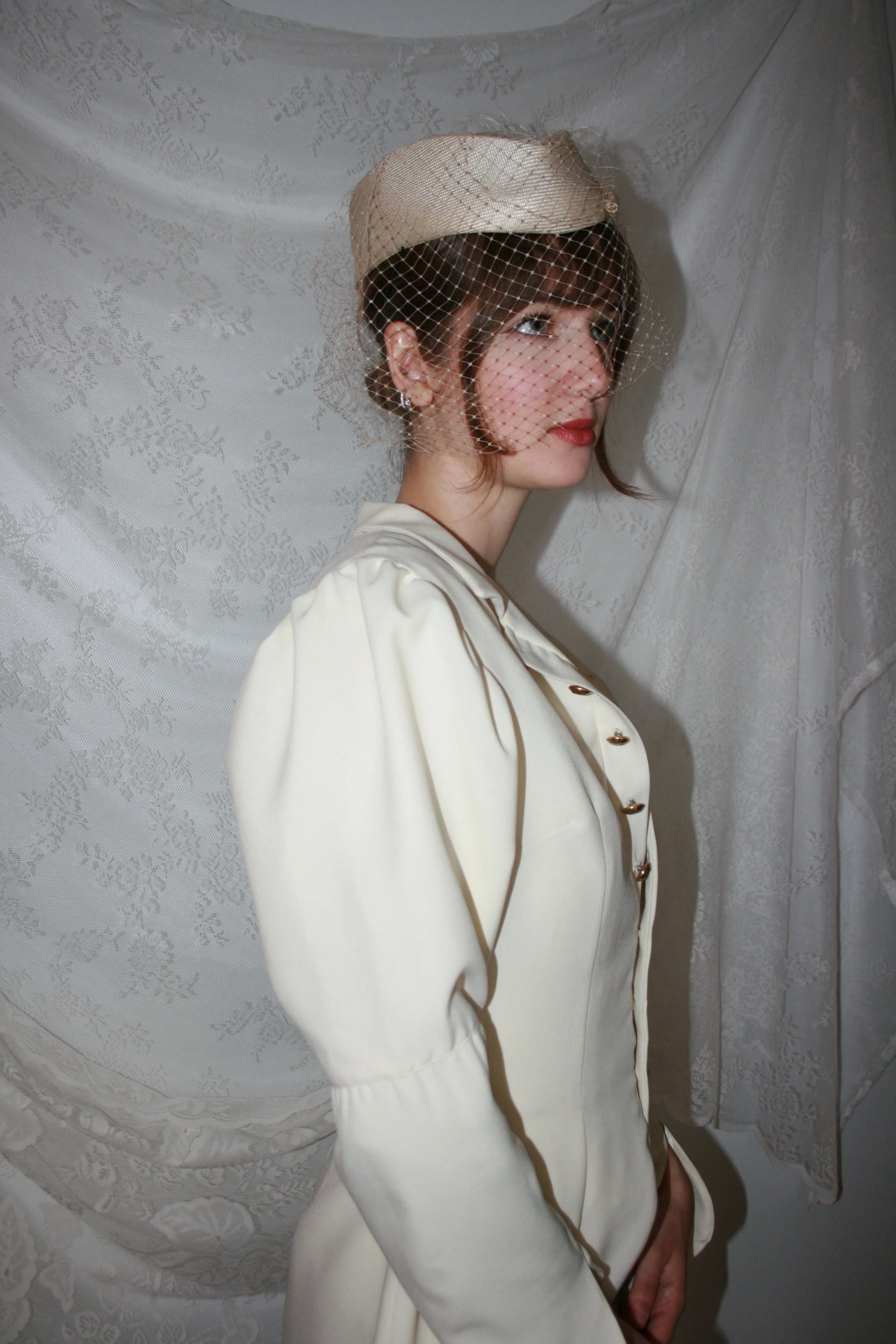 wool gaberdine coat with gathered 3 piece sleeves, standing collar, and gold shank buttons 