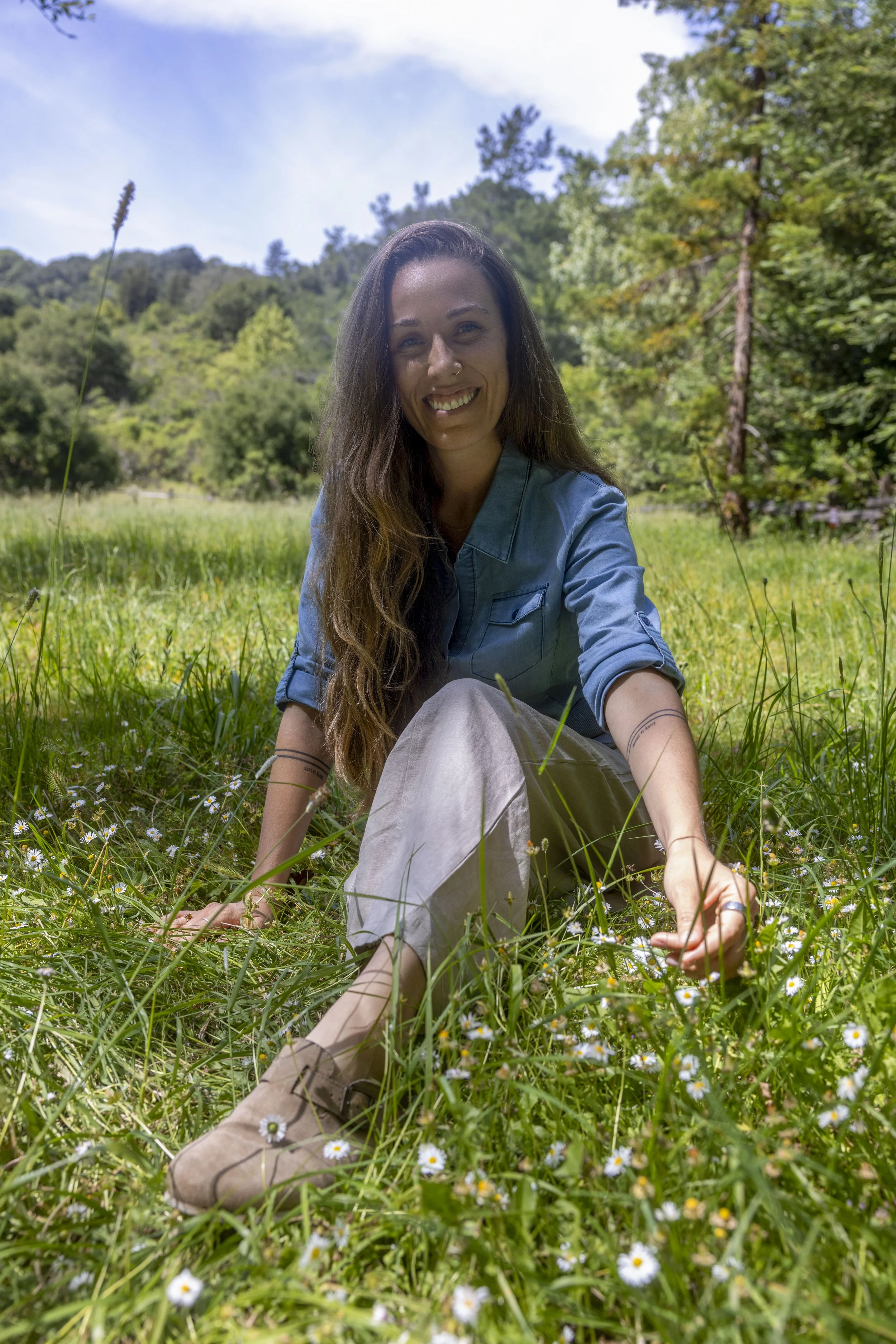 Angela Soley sitting in a sunny meadow