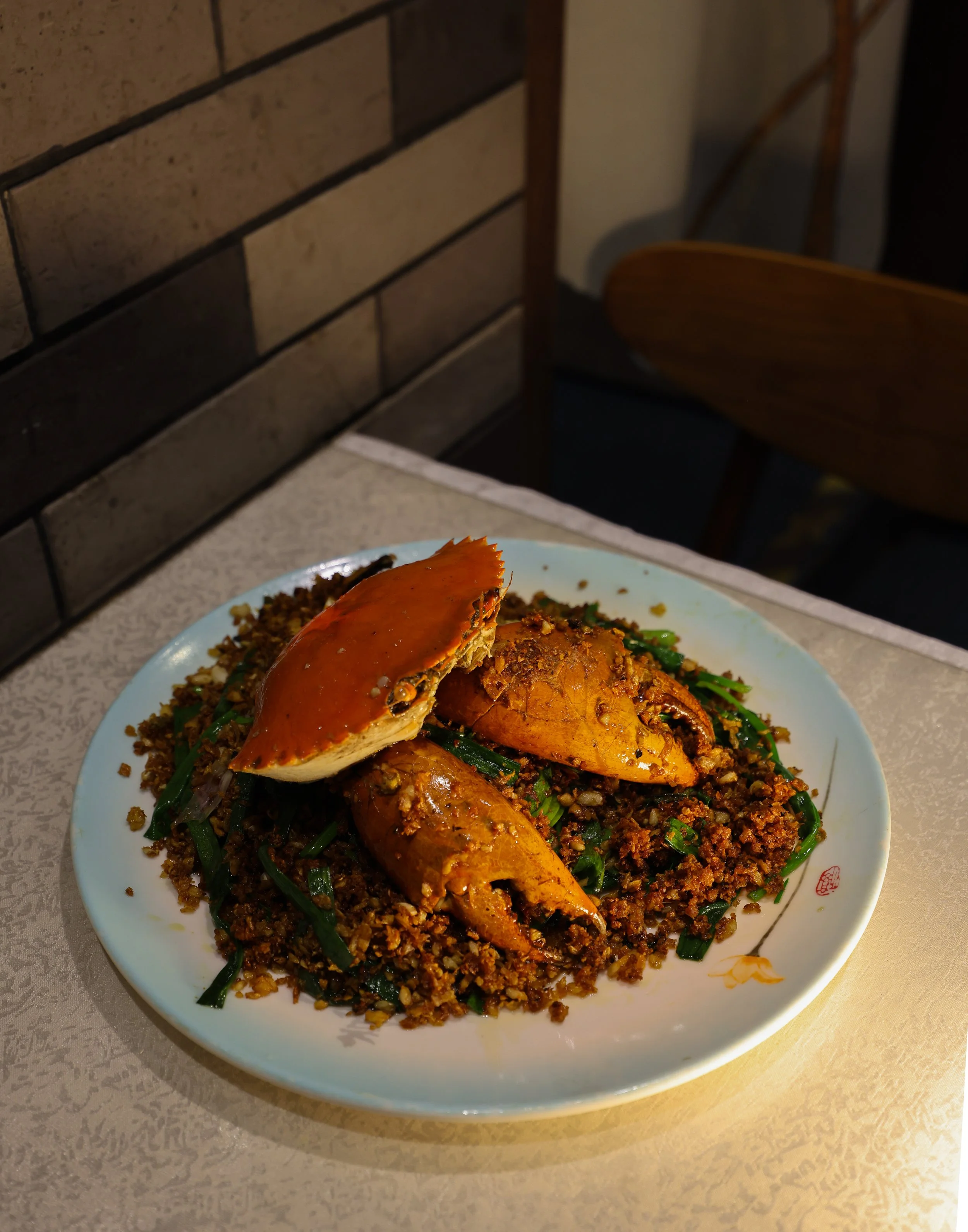 Plat de crabe et riz avec des légumes verts, dans une assiette blanche