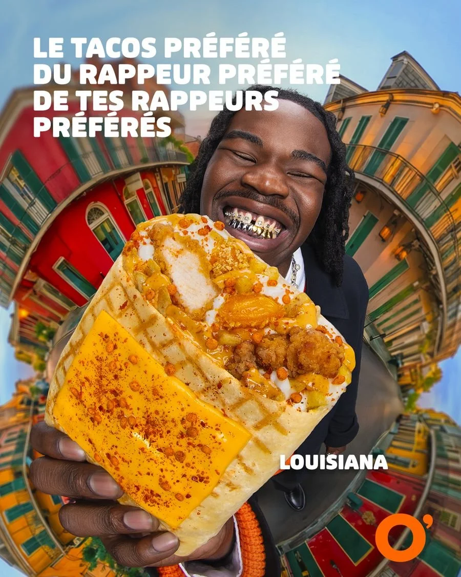 Un homme souriant avec des dents en or, tenant un taco géant rempli de viande, fromage et garnitures, dans un décor coloré de style new-yorkais, avec du texte en français sur l'image.