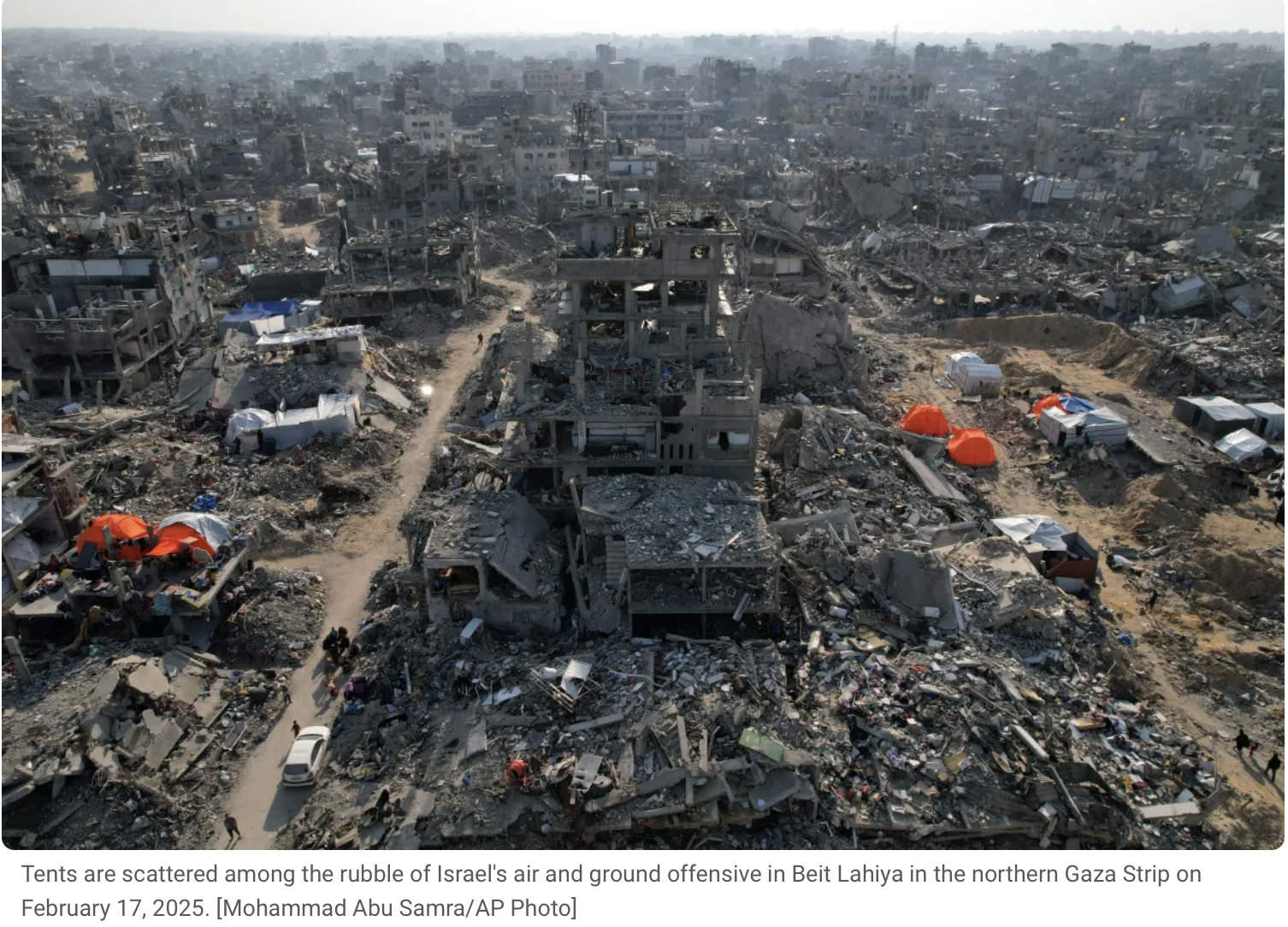 Aerial view of destruction in Beit Lahiya, Gaza Strip, showing damaged buildings, rubble, and scattered tents amid the aftermath of an air and ground offensive.