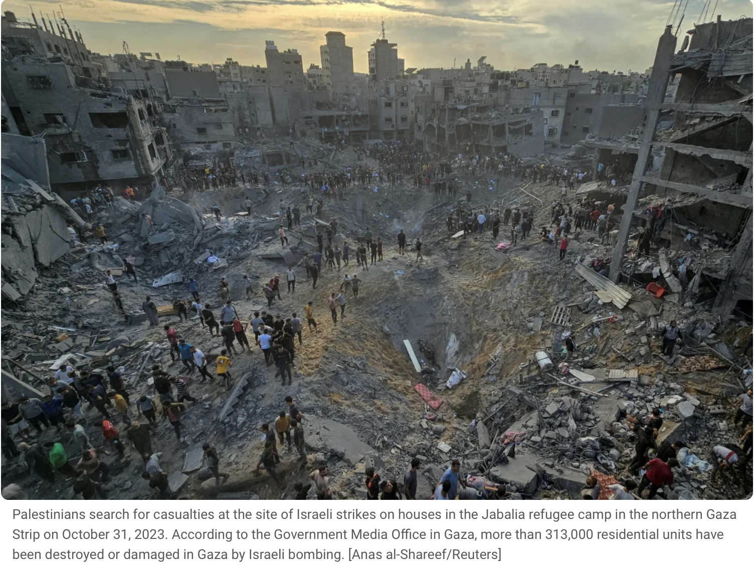 Crowds of people searching among the rubble of destroyed buildings in a city, with damaged structures and debris after Israeli strikes in Gaza.