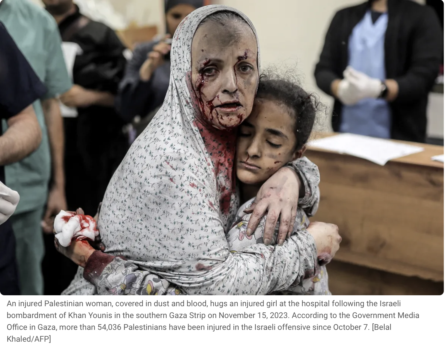 An injured Palestinian woman, covered in dust and blood, hugs an injured girl in a hospital. The woman has visible facial injuries with blood and dirt, and the girl appears to be resting or unconscious, with dirt and minor injuries on her face. The b