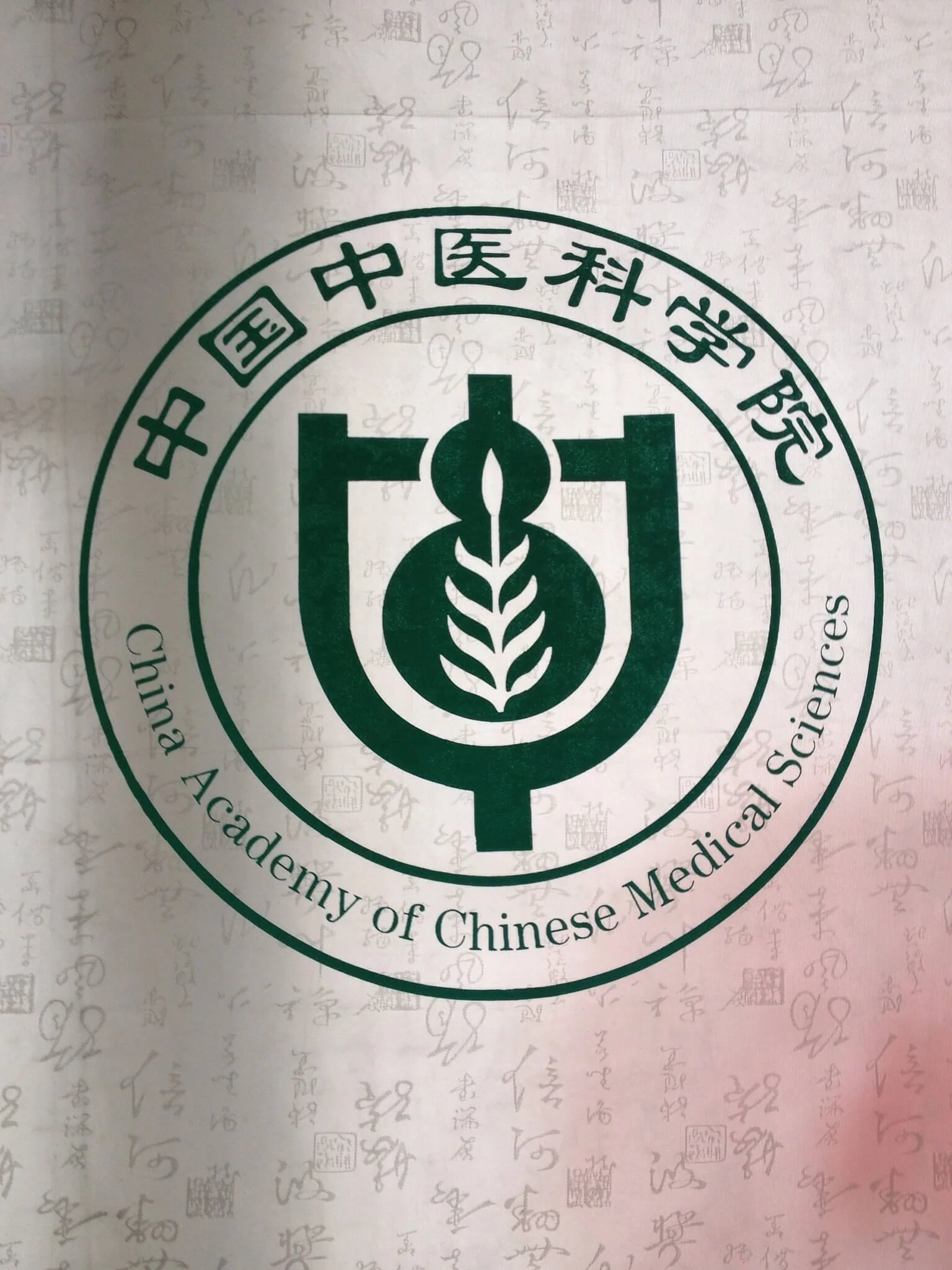 A logo of the World Federation of Chinese Medicine Societies on a sheet with faint handwritten Chinese characters.