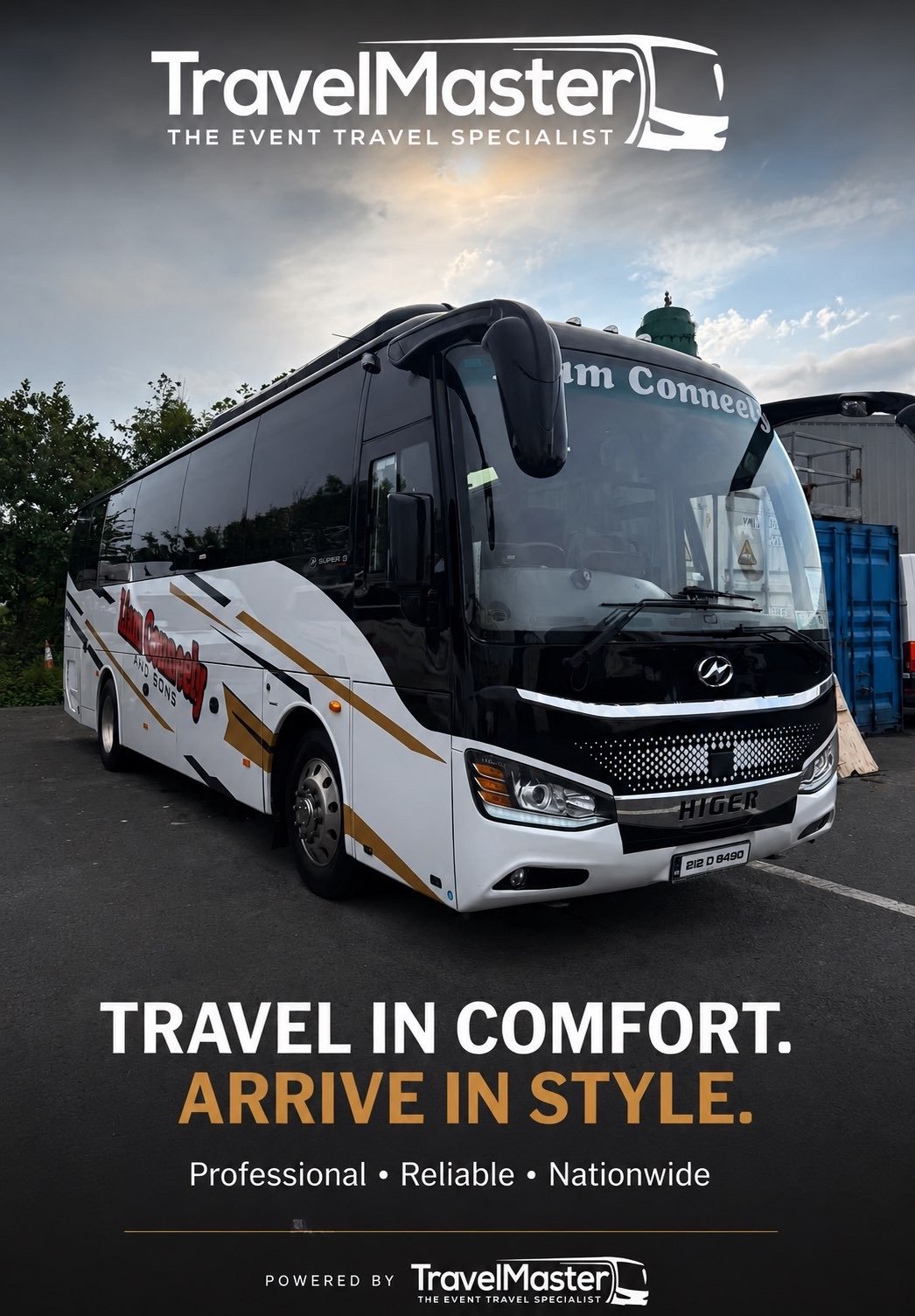 A black and white tour bus with gold accents parked outdoors, advertising travel services by TravelMaster with the slogan 'Travel in Comfort. Arrive in Style.' It features a large windshield and side mirrors, and is branded "Higer."