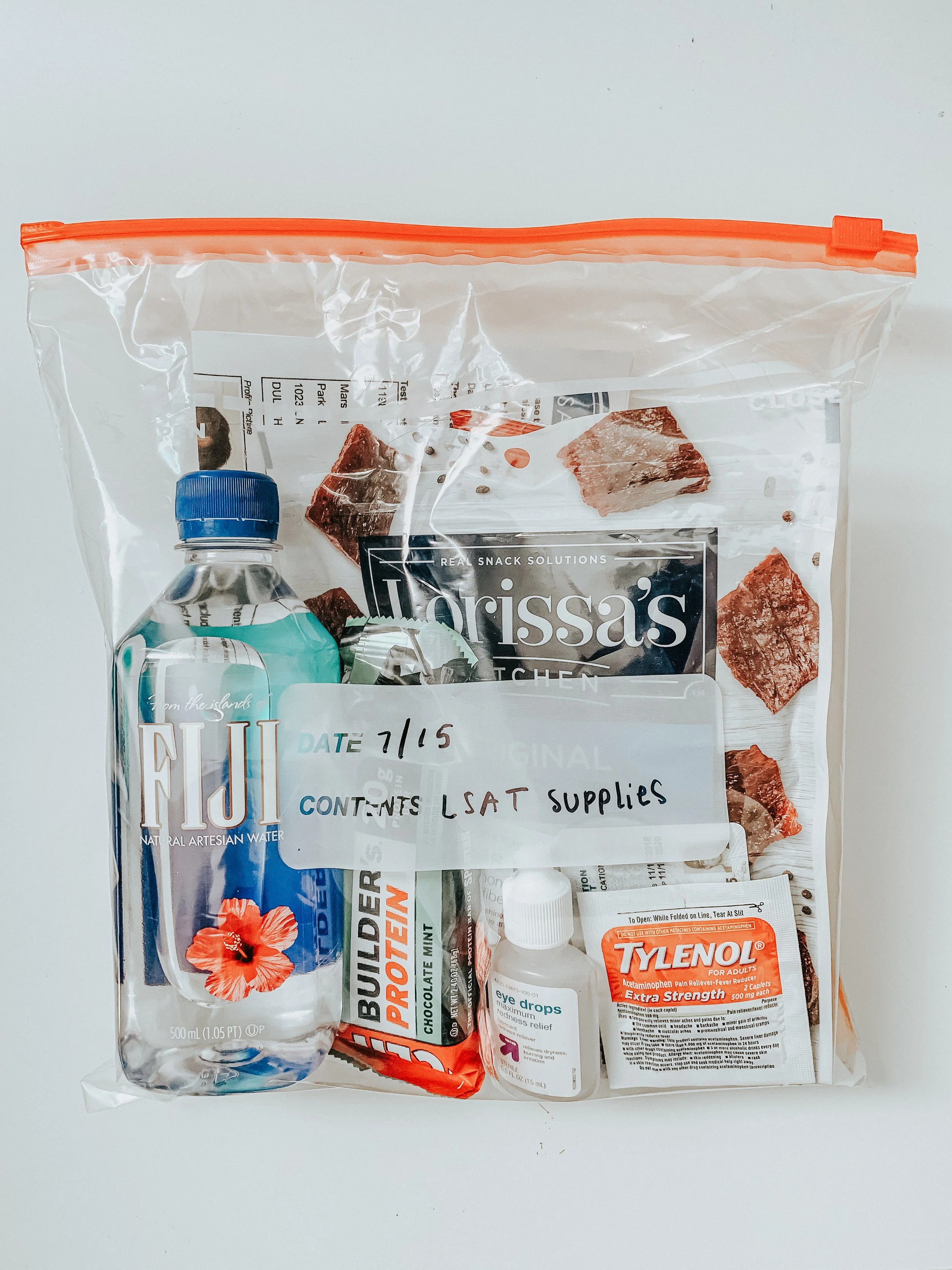 Photo of a plastic bag with Marin's LSAT supplies (snacks, water, Tylenol, etc.)