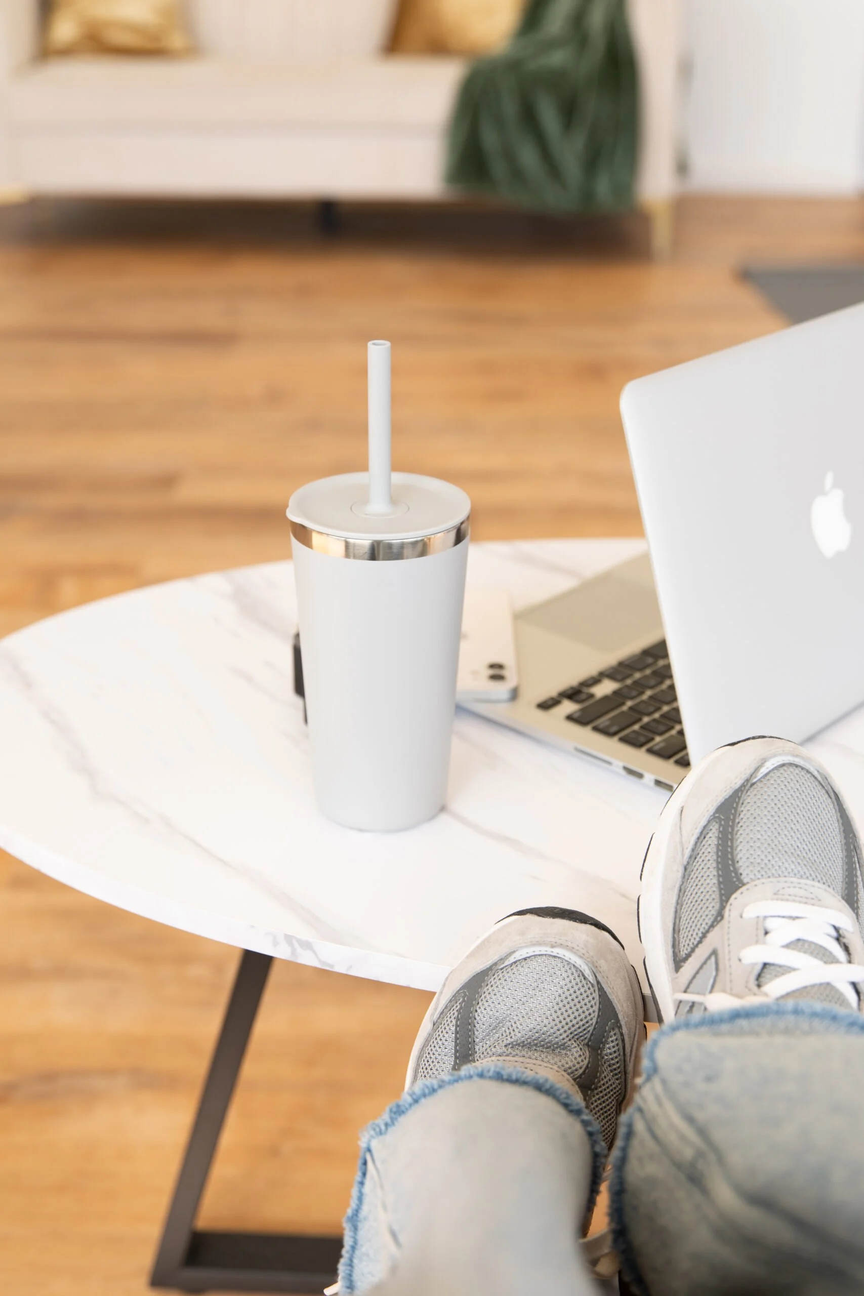 Photo of a person's feet up in front of a laptop and water bottle