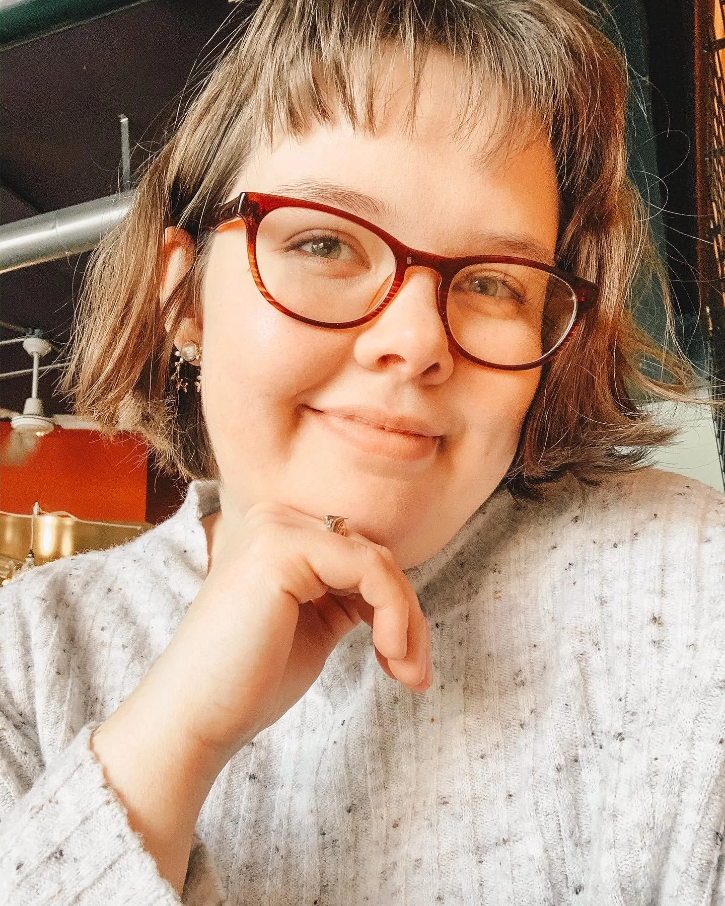 Photo of Marin up close, smiling and wearing glasses