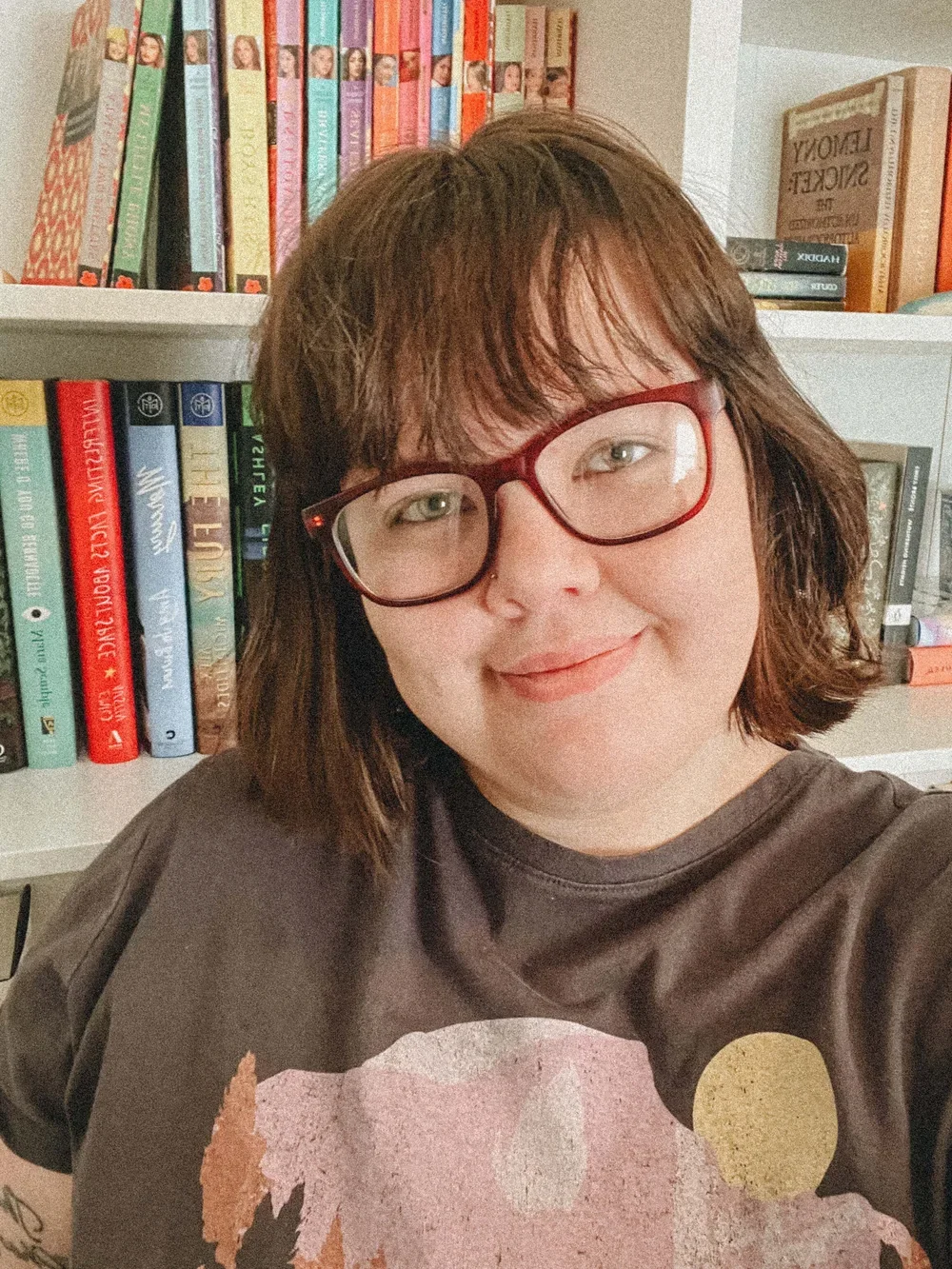 Photo of Marin in front of a bookshelf