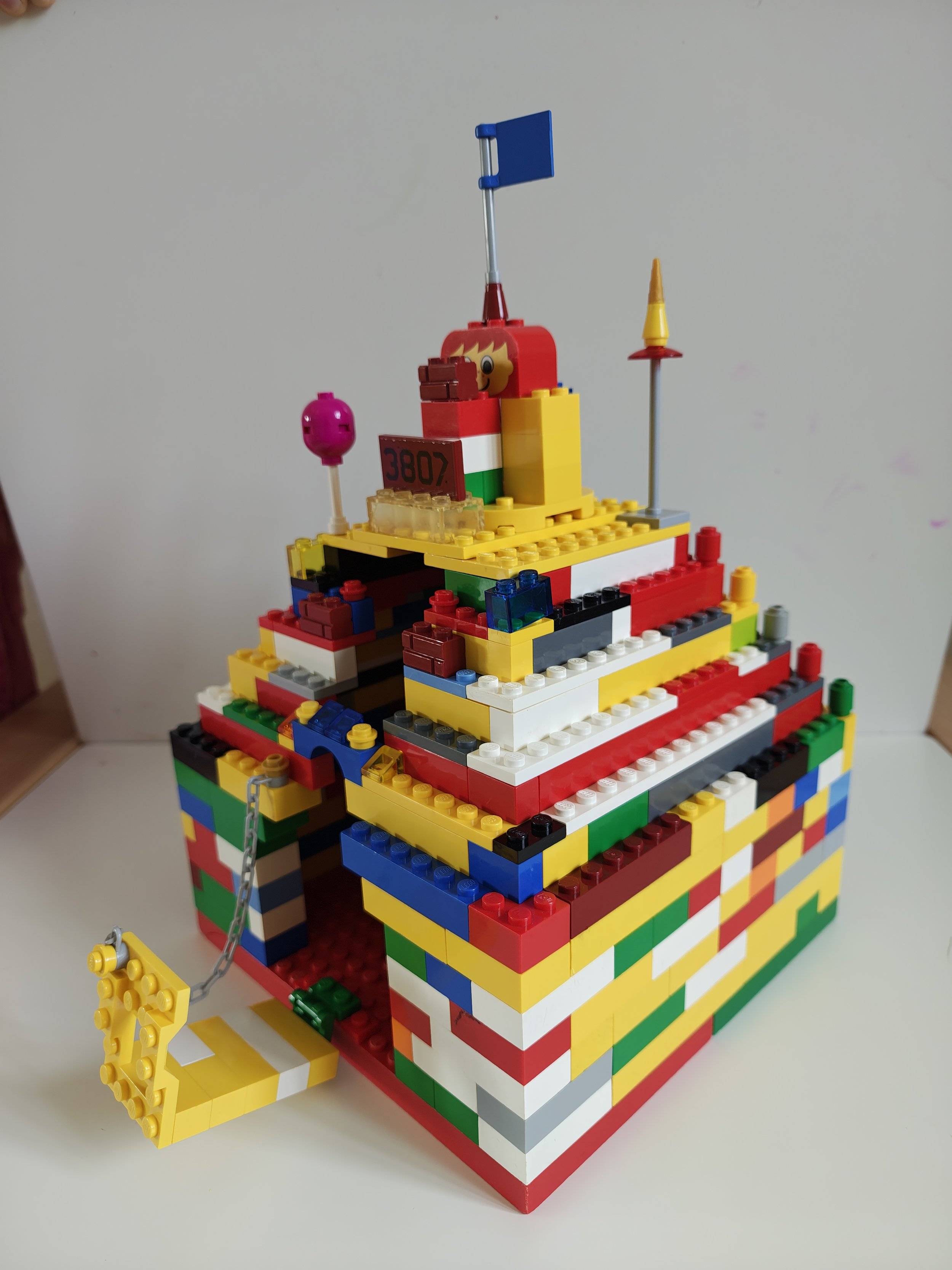 Colorful LEGO structure resembling a building or castle with flags and decorative elements.
