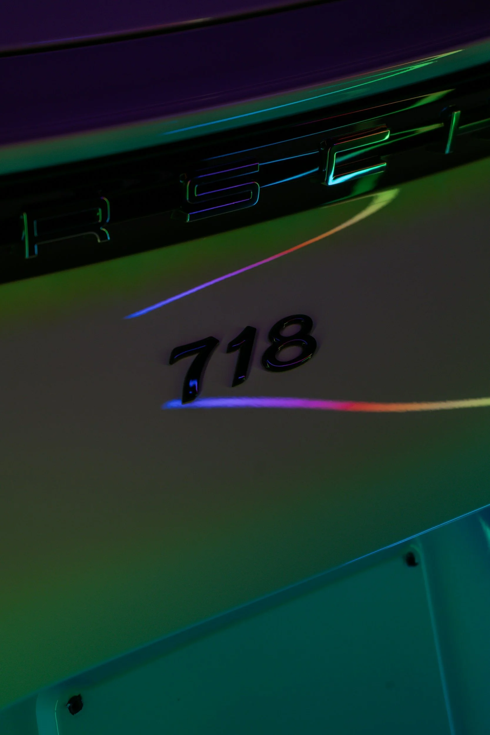 Close-up of the illuminated 'ROG' logo on a gaming laptop with rainbow-colored light reflections.