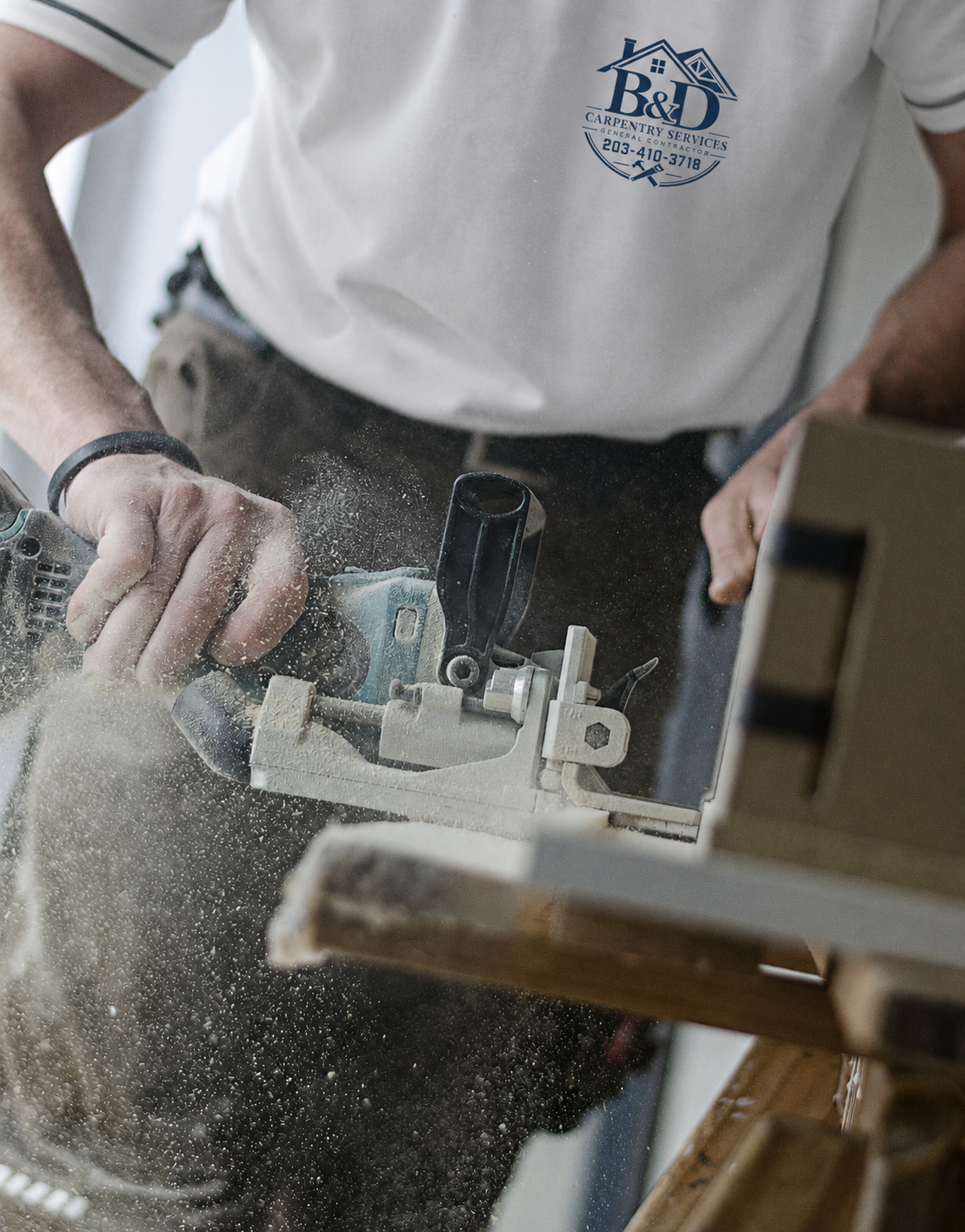 A person using a hand-held power saw to cut wood in a workshop, with sawdust flying.