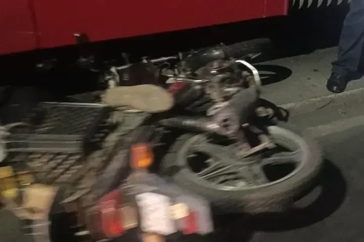 Motocicleta accidentada en la calle, con daños visibles y destrucción. Lugar oscuro, posible escena de accidente.