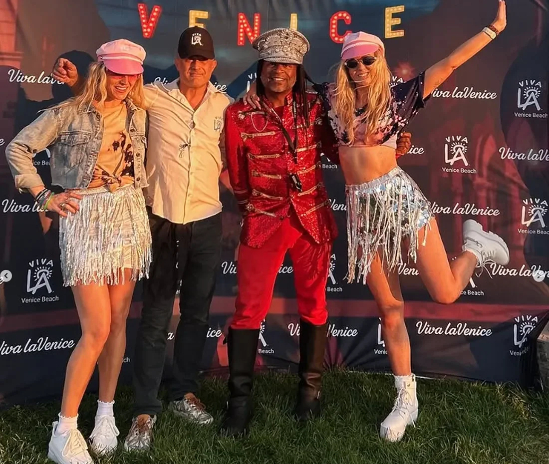 Four people pose in front of a backdrop with
