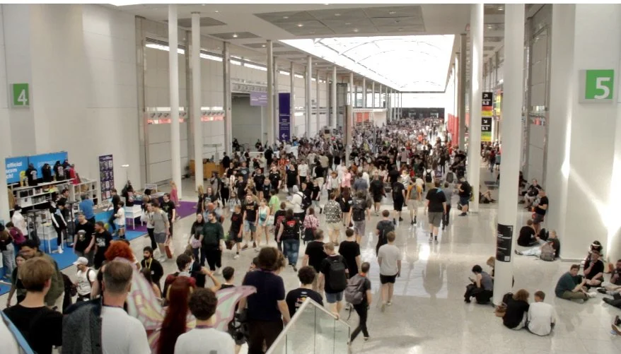 Busy exhibition hall at Koelnmesse trade fair with crowds of visitors