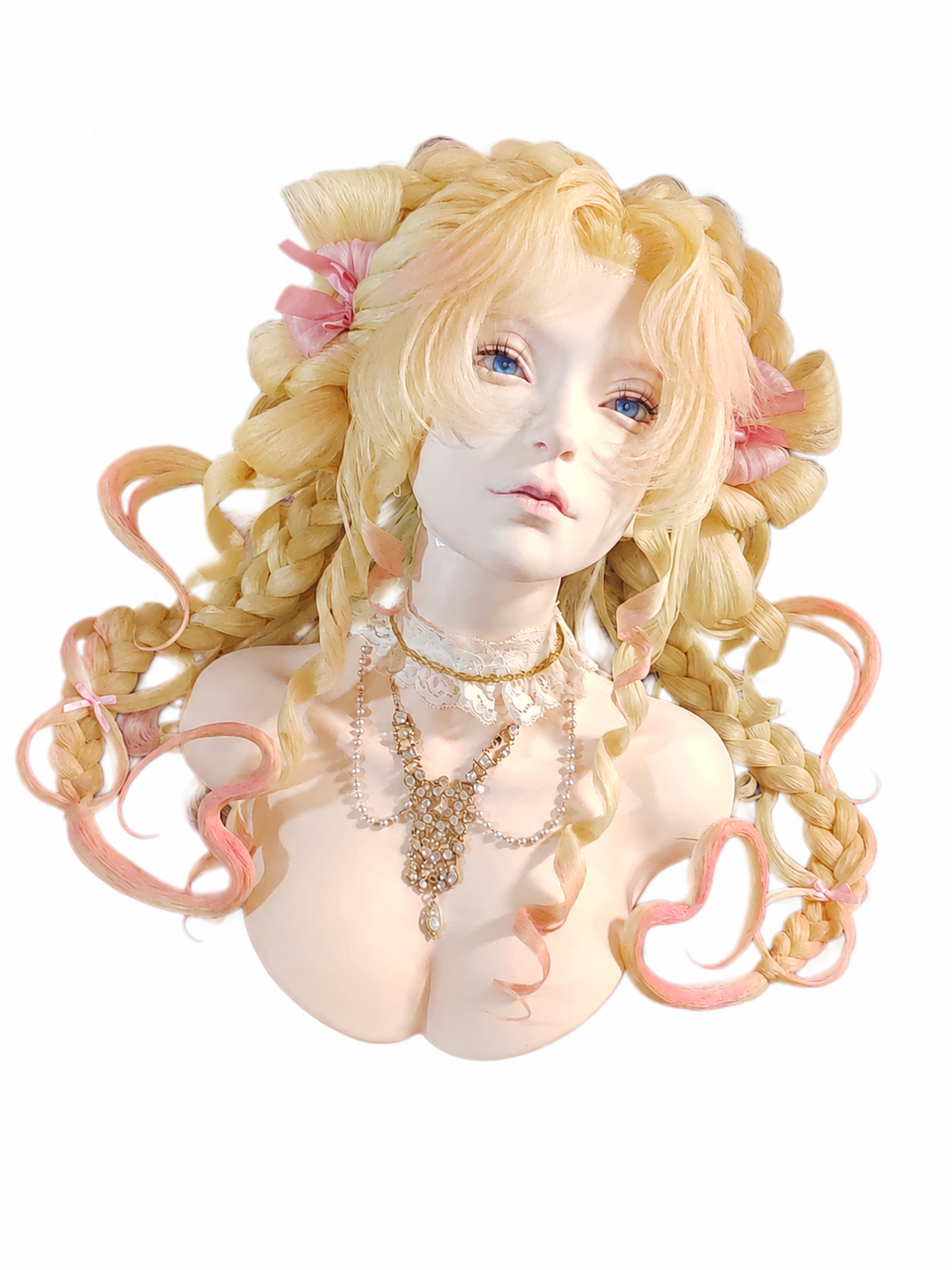 Bust of a doll with long blonde curls, pink ribbons, blue eyes, wearing pearl and gold jewelry, and a white lace choker.